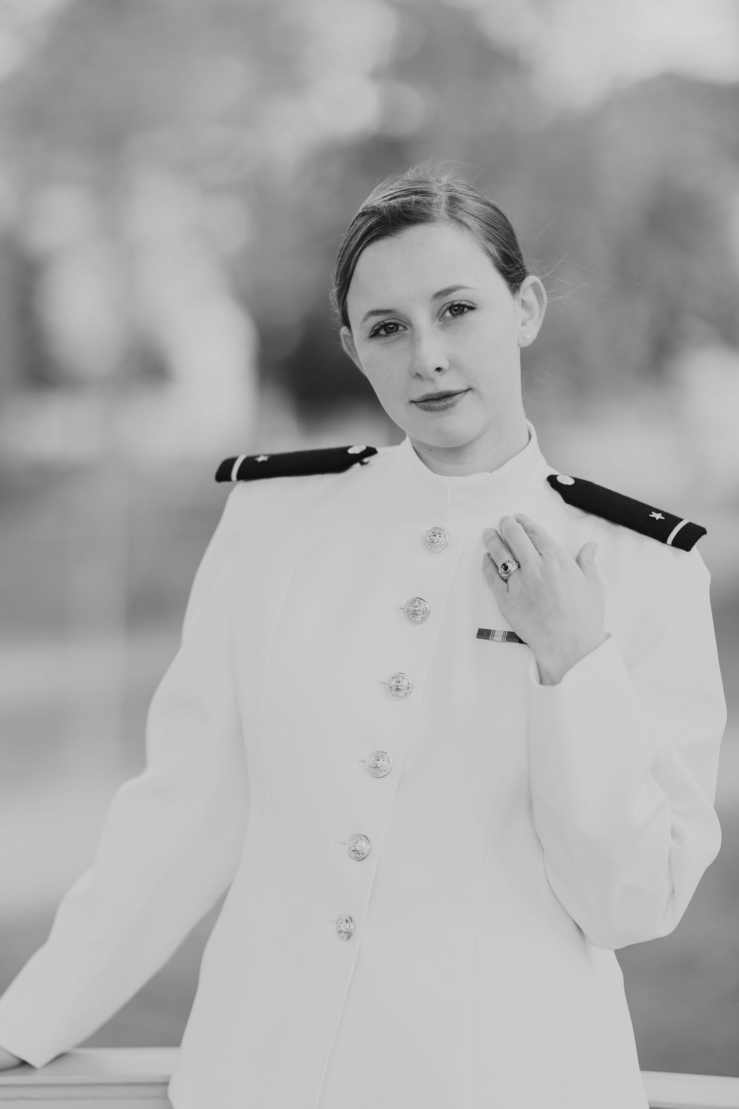 Black and white portrait of service member in formal white military dress uniform with decorative buttons.