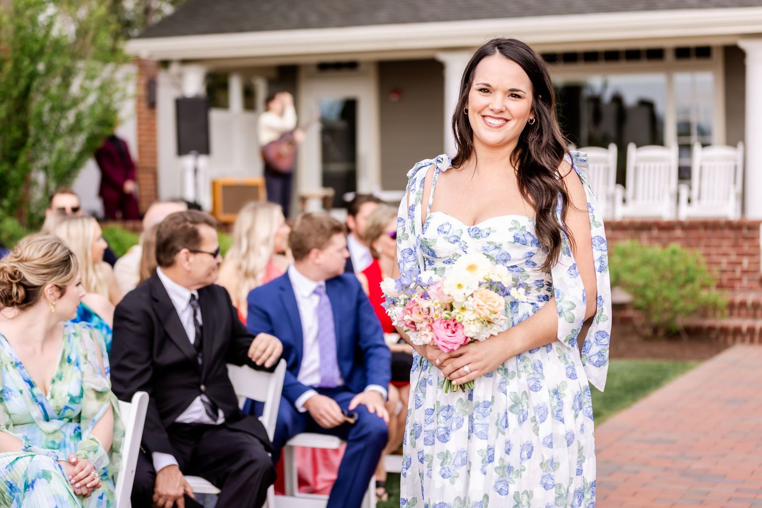 Guests in formal attire gathering for an outdoor spring wedding celebration.
