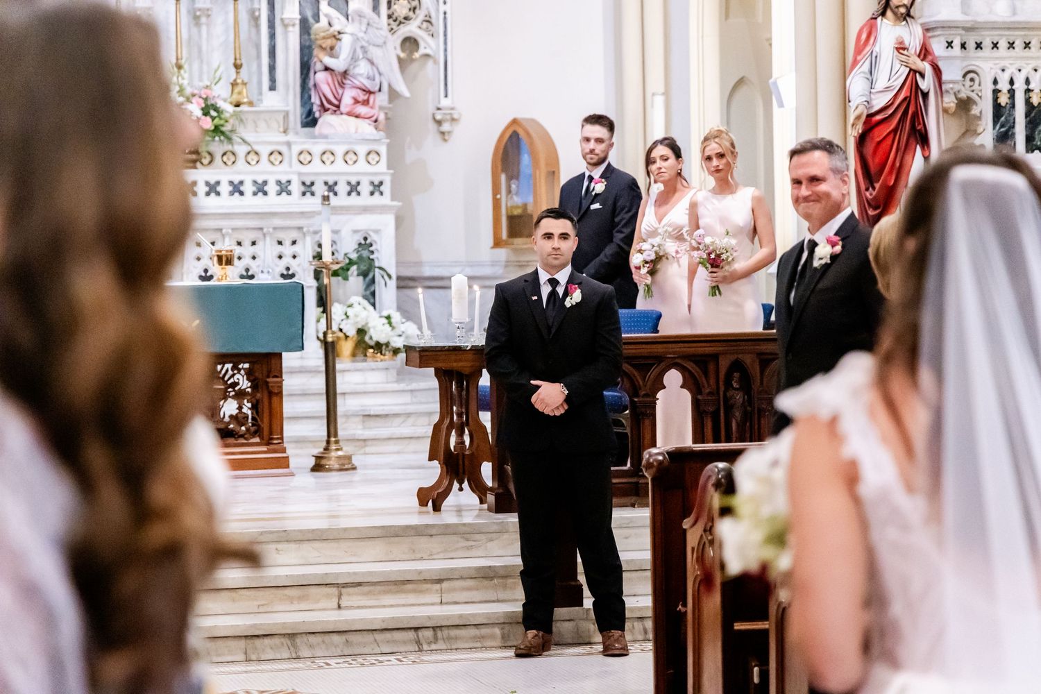 Wedding ceremony taking place in ornate church with traditional decor and architecture.