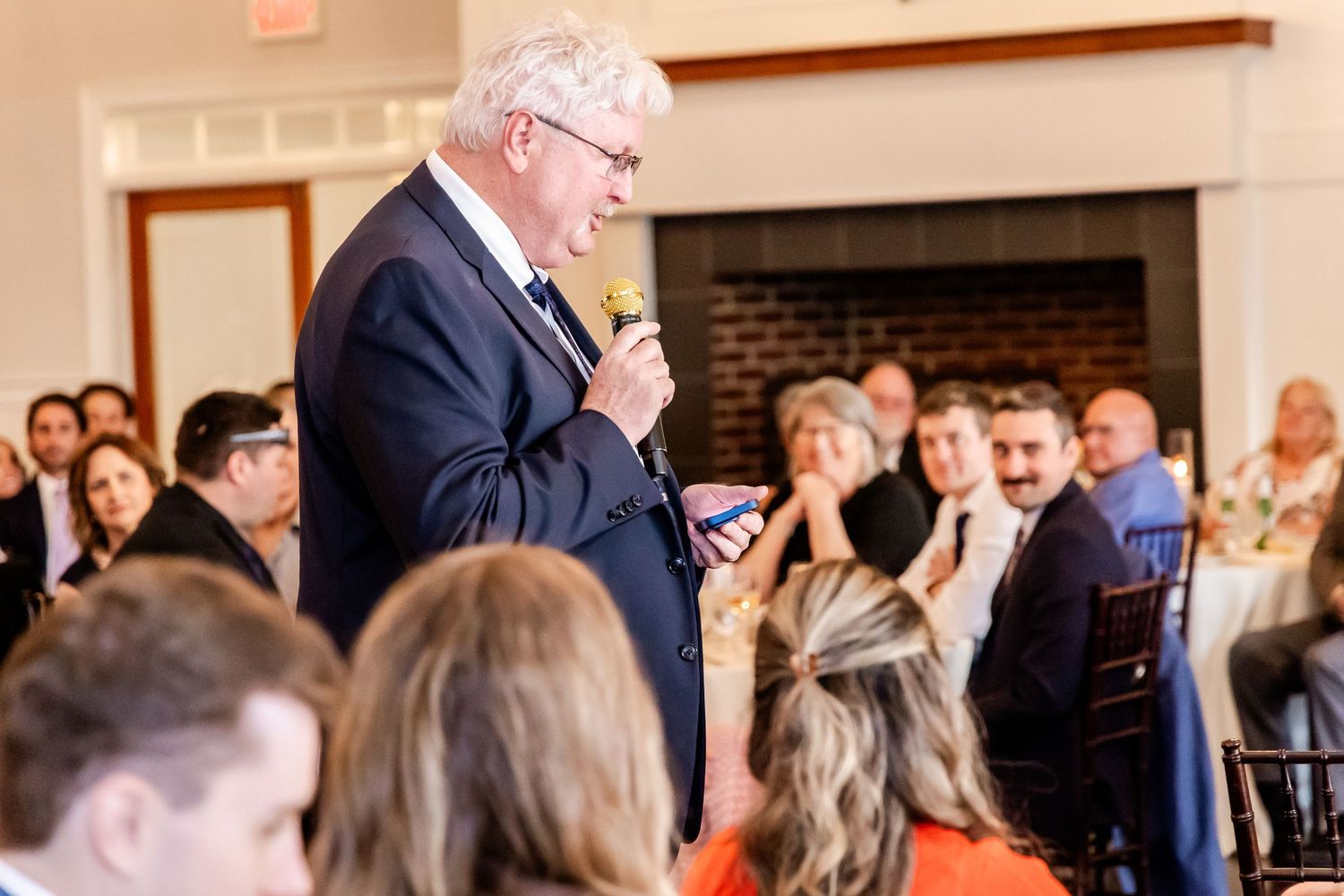 Wedding reception scene showing guests seated at tables in an elegant indoor venue.