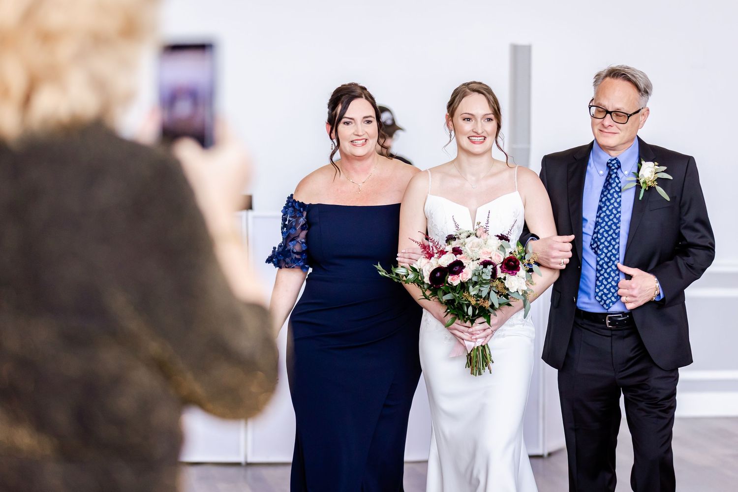 Wedding party members pose together in formal attire during the ceremony.