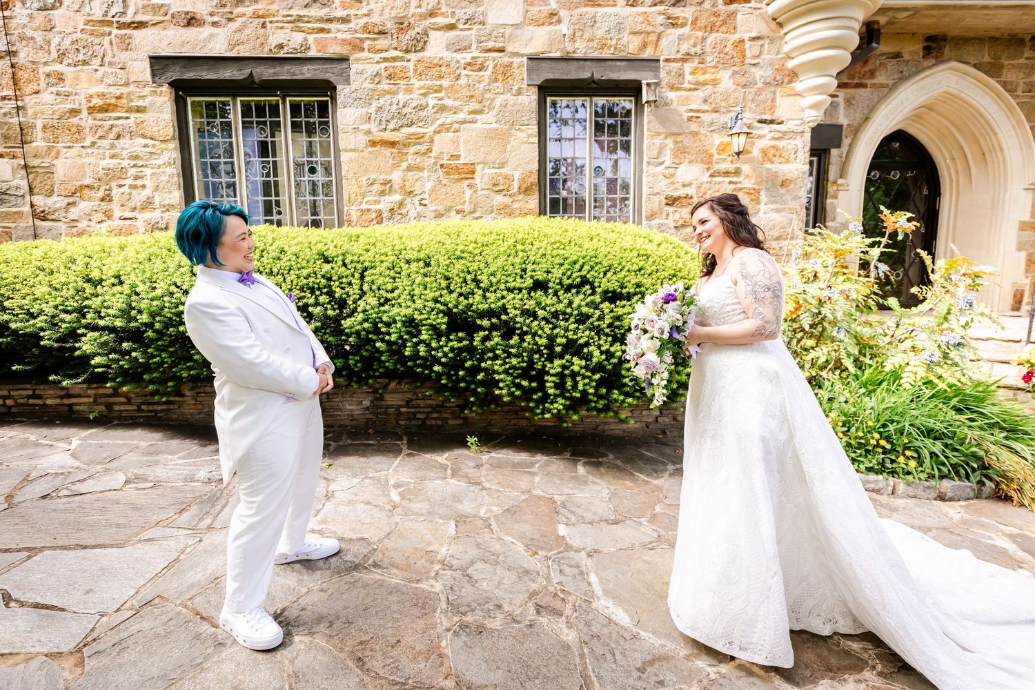Wedding photos taken at a stone castle with couple in white outfits on stone pathway.