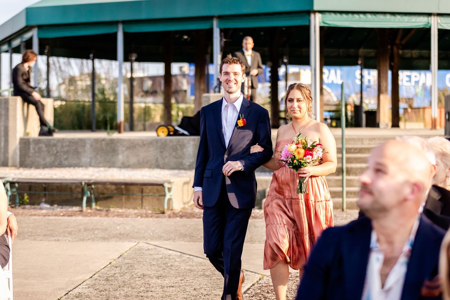 Wedding procession walking along a path on a sunny day.