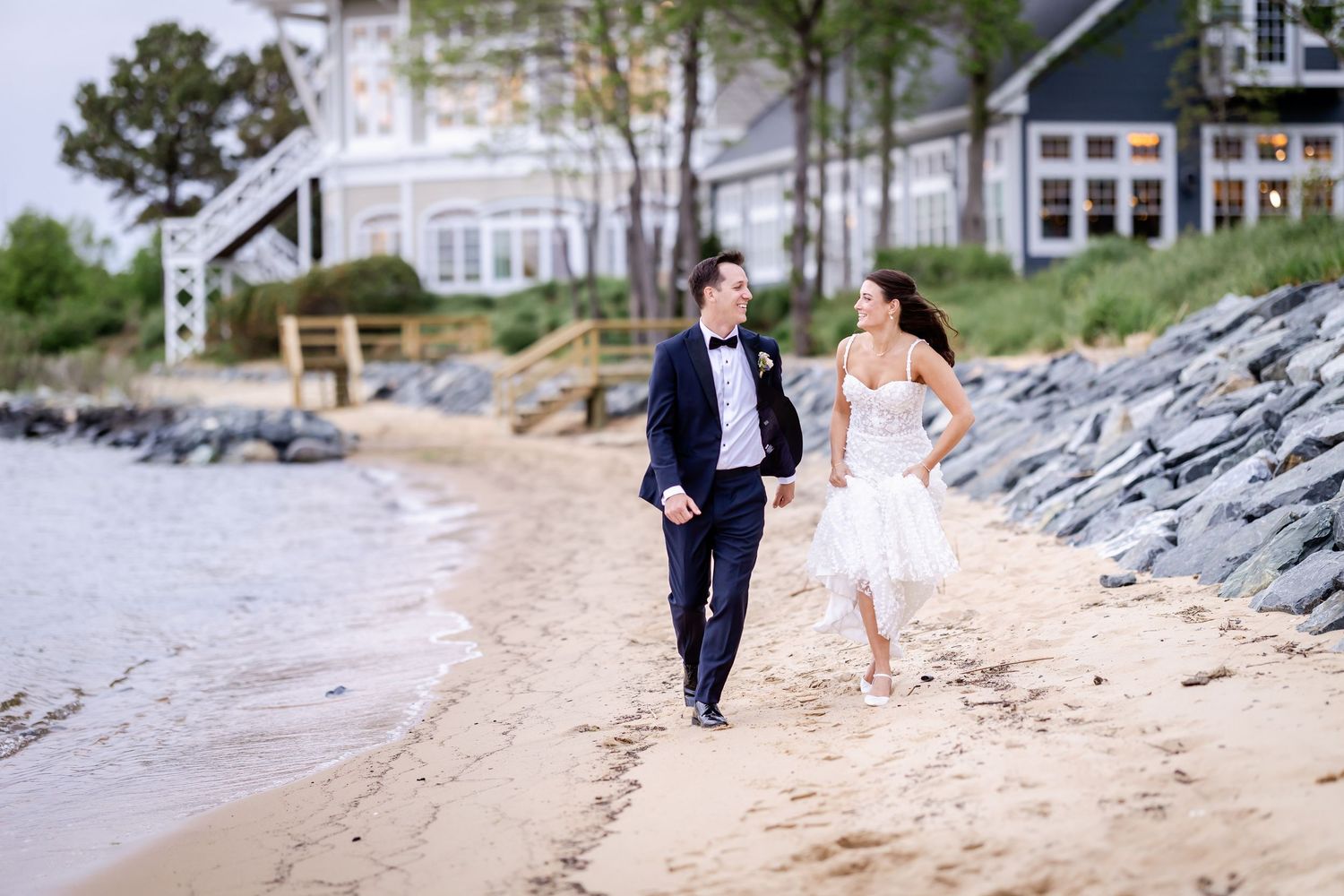Couple walking along a scenic beach boardwalk during a romantic photoshoot session.