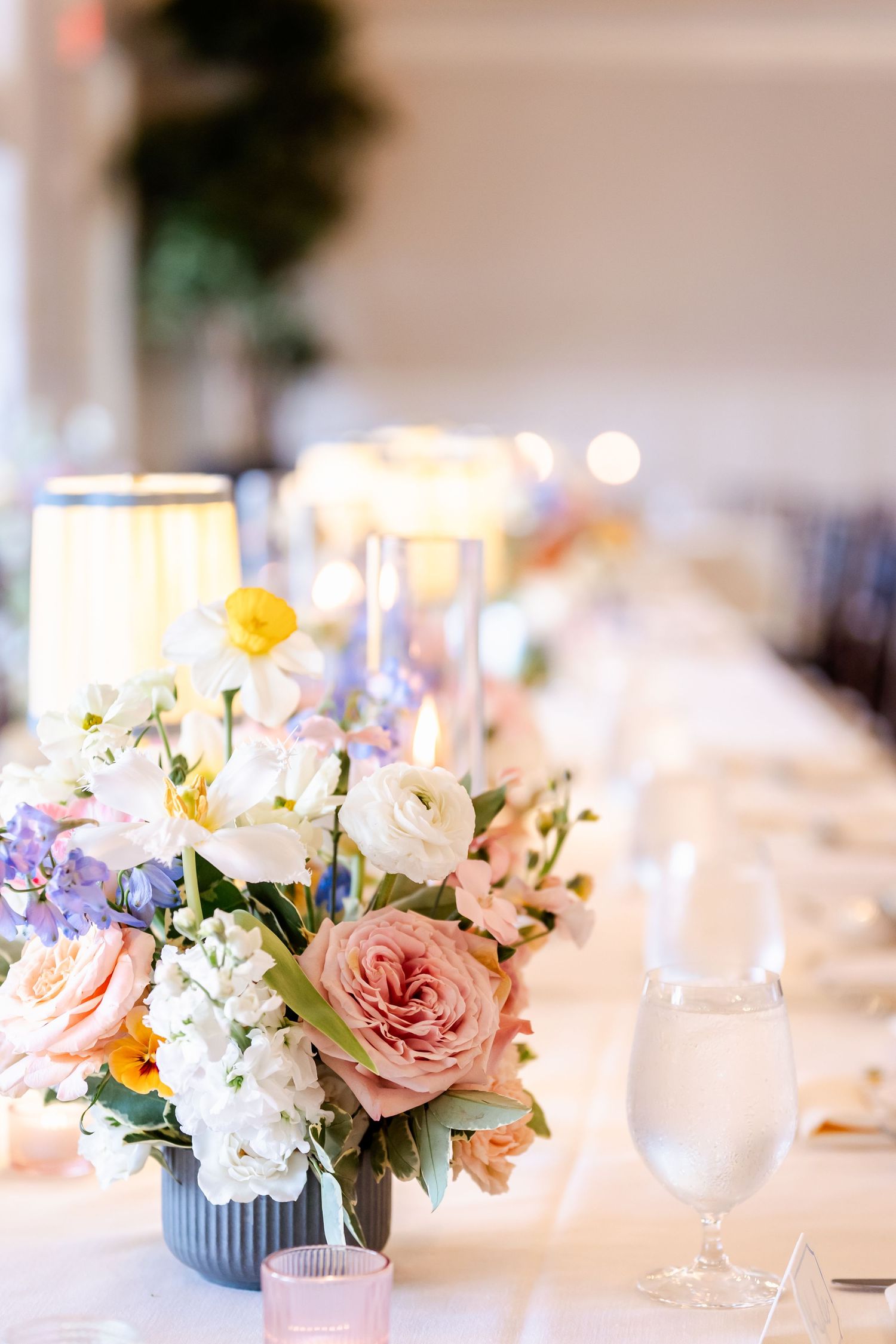 Elegant wedding table centerpiece with roses, hydrangeas and candlelight.