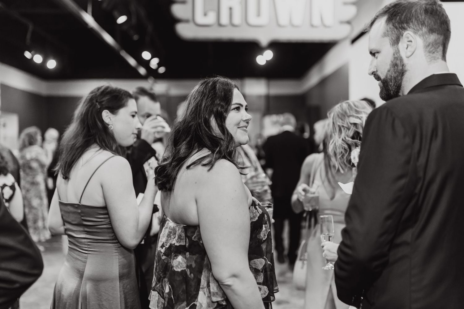 Wedding reception guests mingling and socializing at indoor venue.