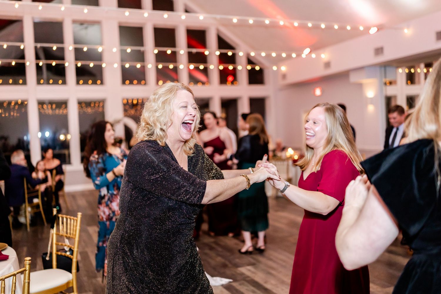 Wedding reception dance floor with string lights and guests enjoying the celebration.
