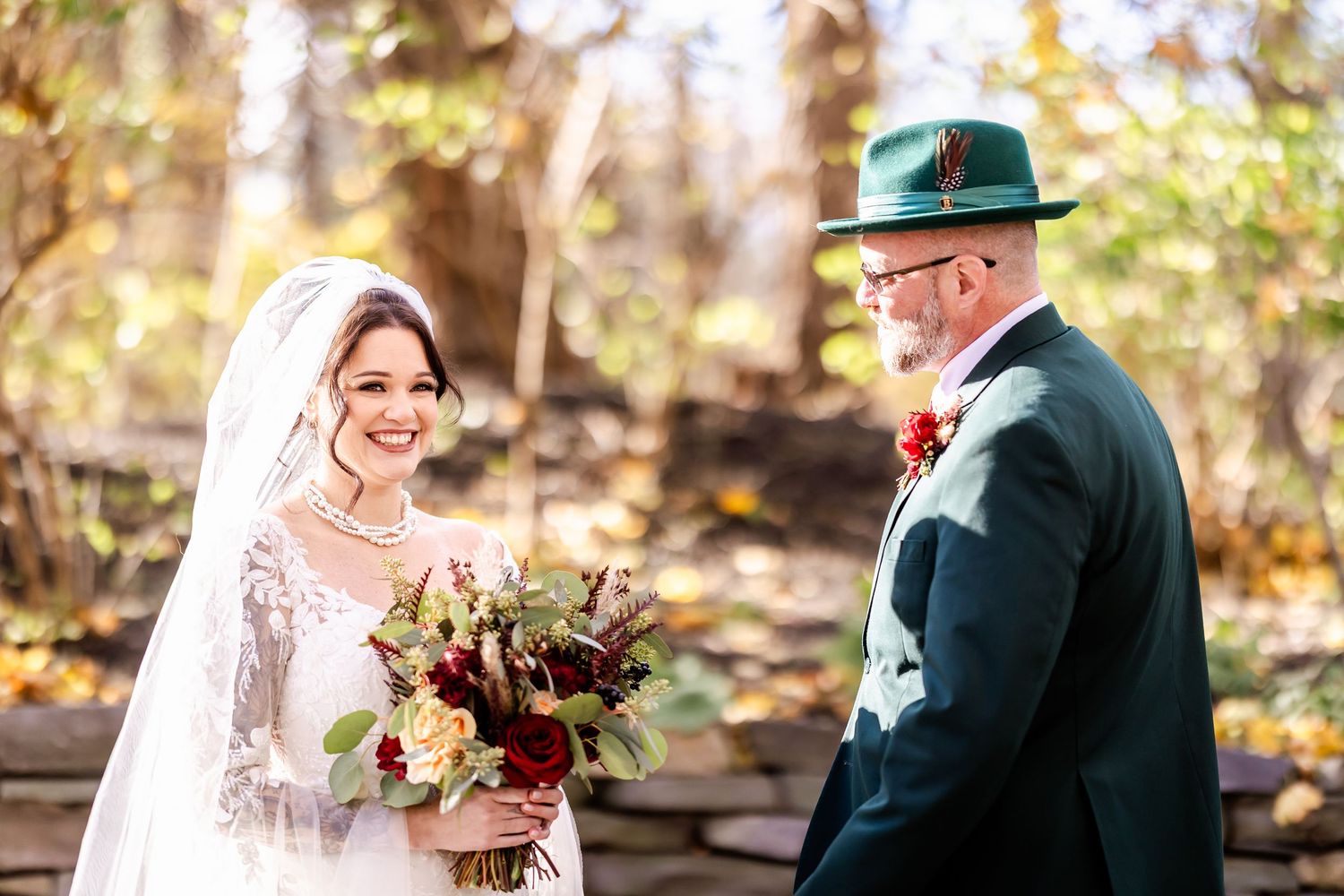 Wedding couple shares intimate first look moment in autumn forest setting.
