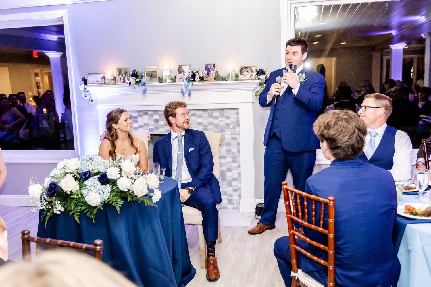 Wedding reception celebration with guests dancing under blue lighting in an elegant venue.