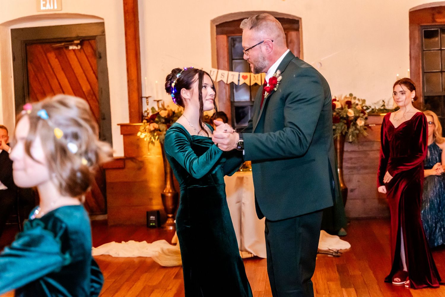 Couples dancing together during a wedding reception in an elegant indoor venue.