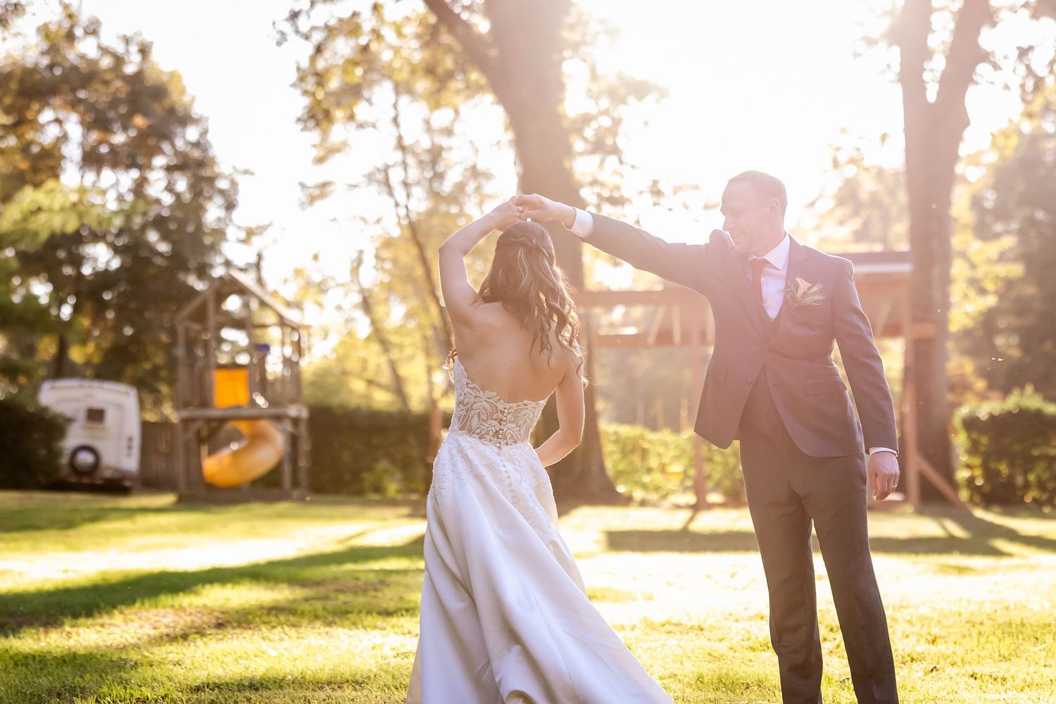 Golden hour wedding photos capture couple walking and embracing in sunlit outdoor setting.