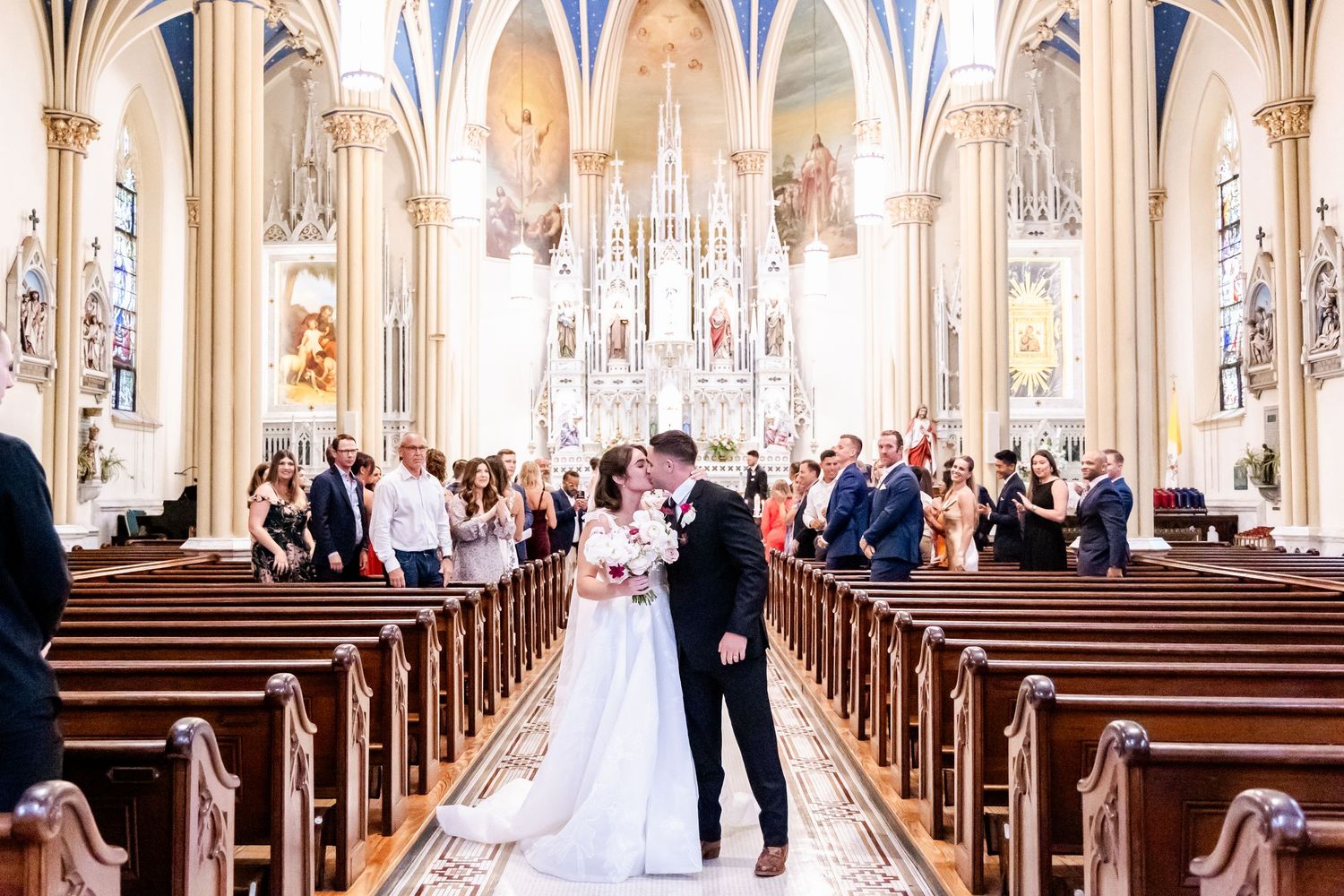A wedding ceremony in a grand cathedral with ornate architecture and stained glass windows.