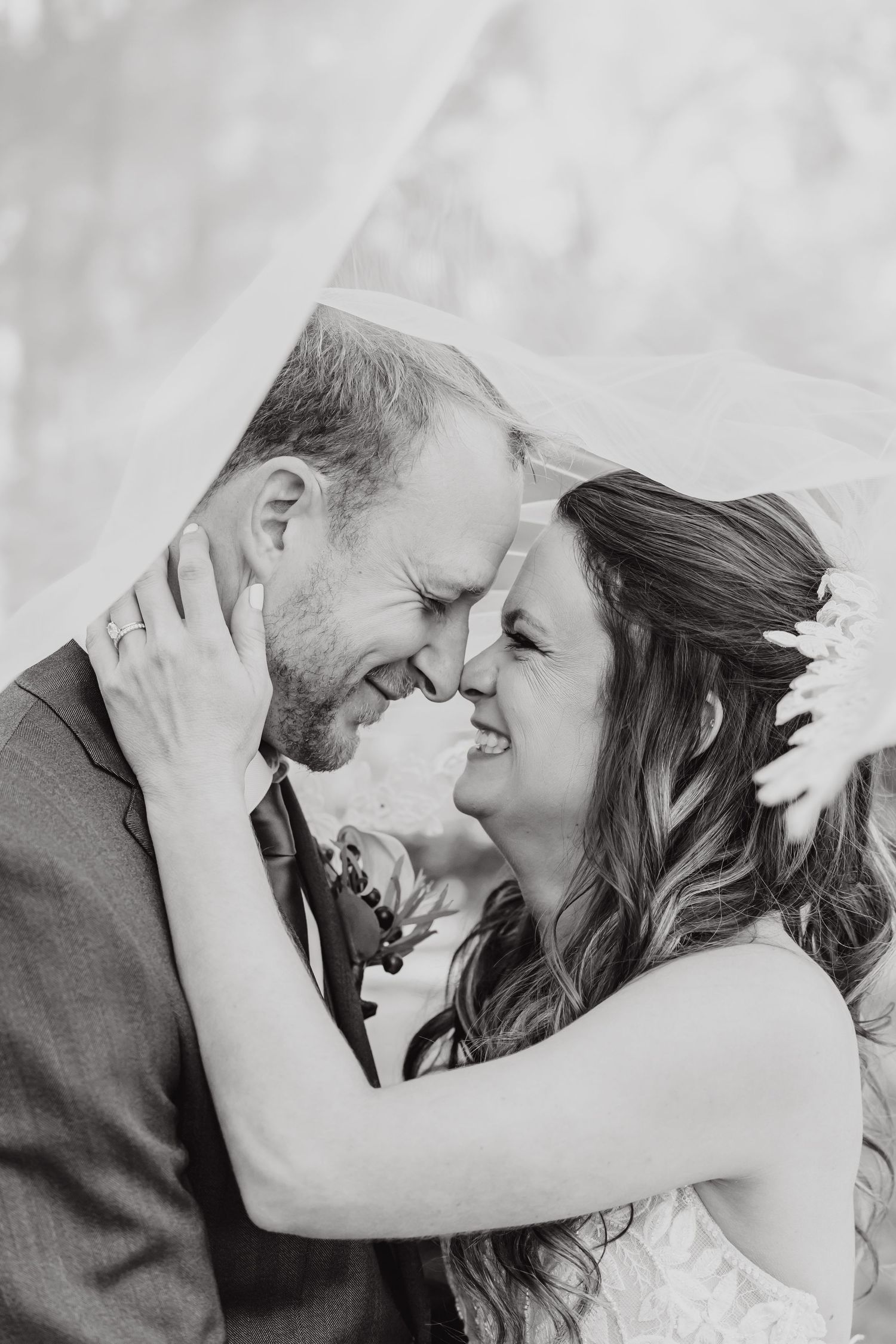 Black and white romantic wedding photos showing intimate moments between newlyweds against neutral background.