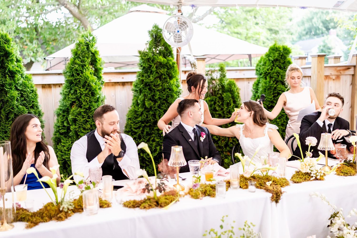A panoramic sequence of wedding guests enjoying an outdoor reception celebration at elegant tables.