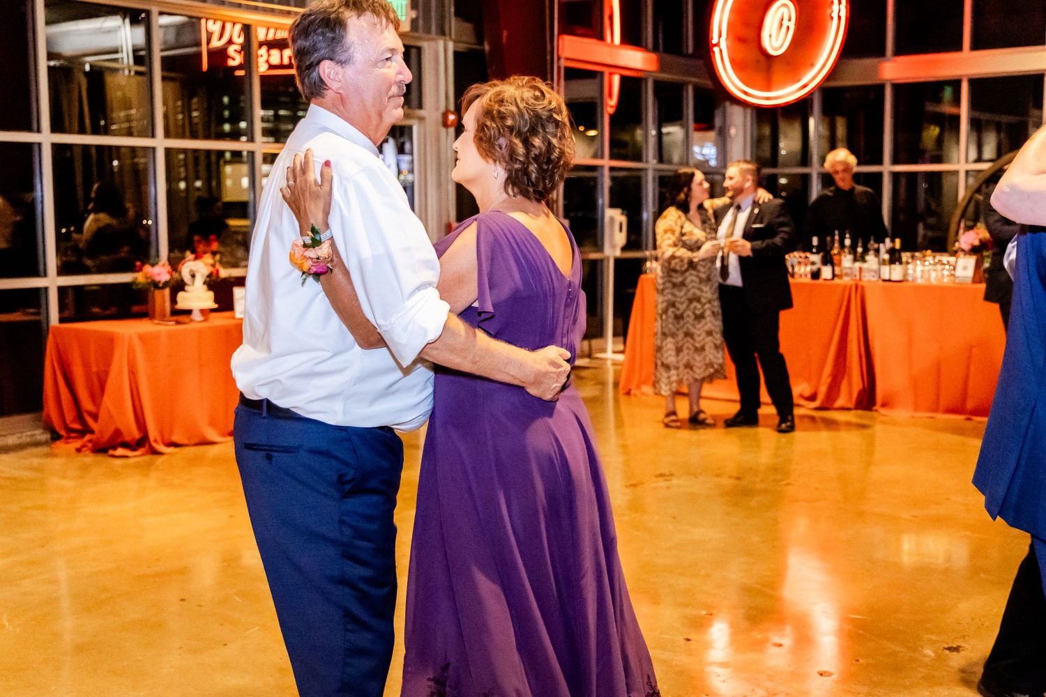 Wedding reception dancers in purple and white moving across dance floor.