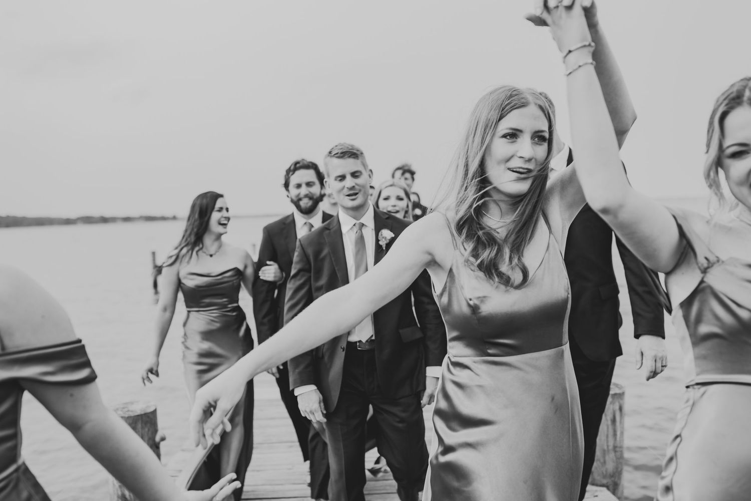 Black and white wedding photo collage showing candid moments of guests celebrating and dancing at a reception.