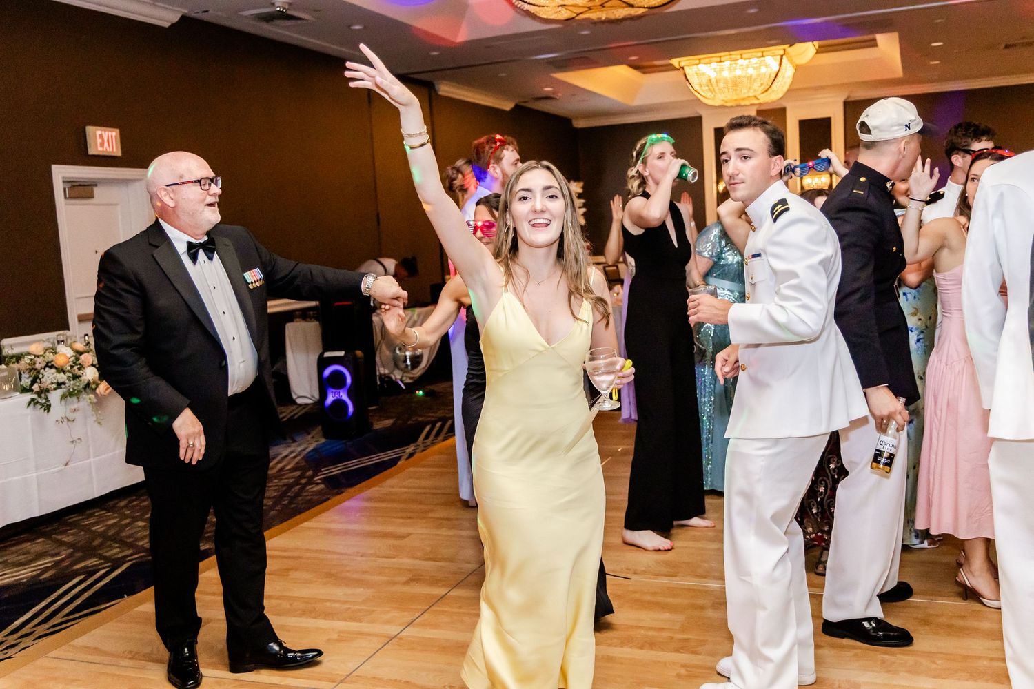 Wedding reception party with guests dancing and celebrating in formal attire.