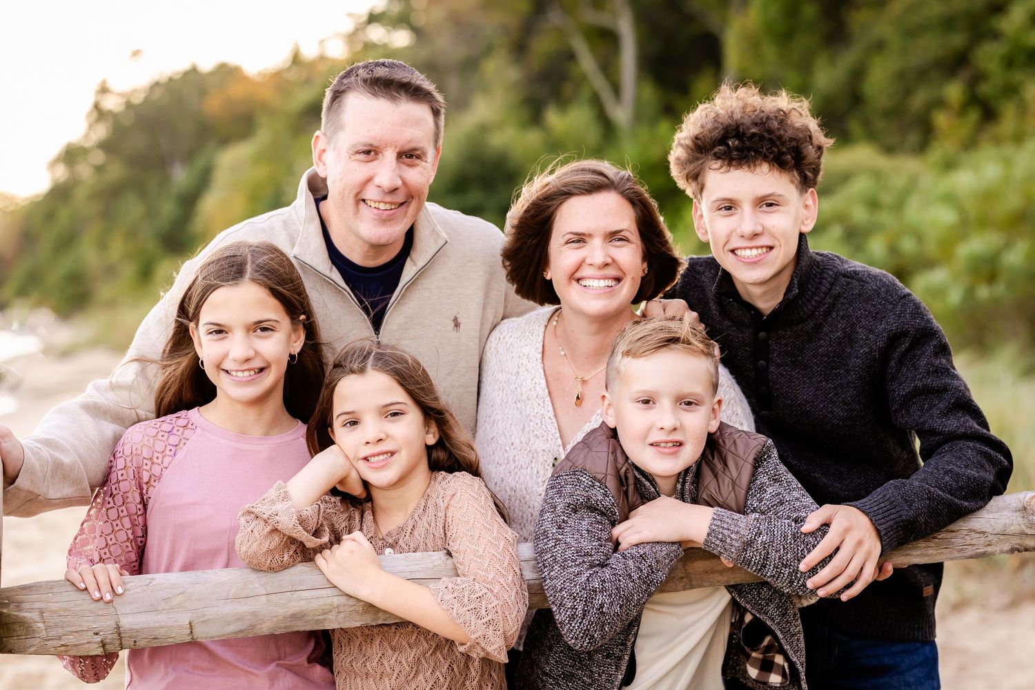 Casual group portrait on beach with natural lighting and coastal scenery.