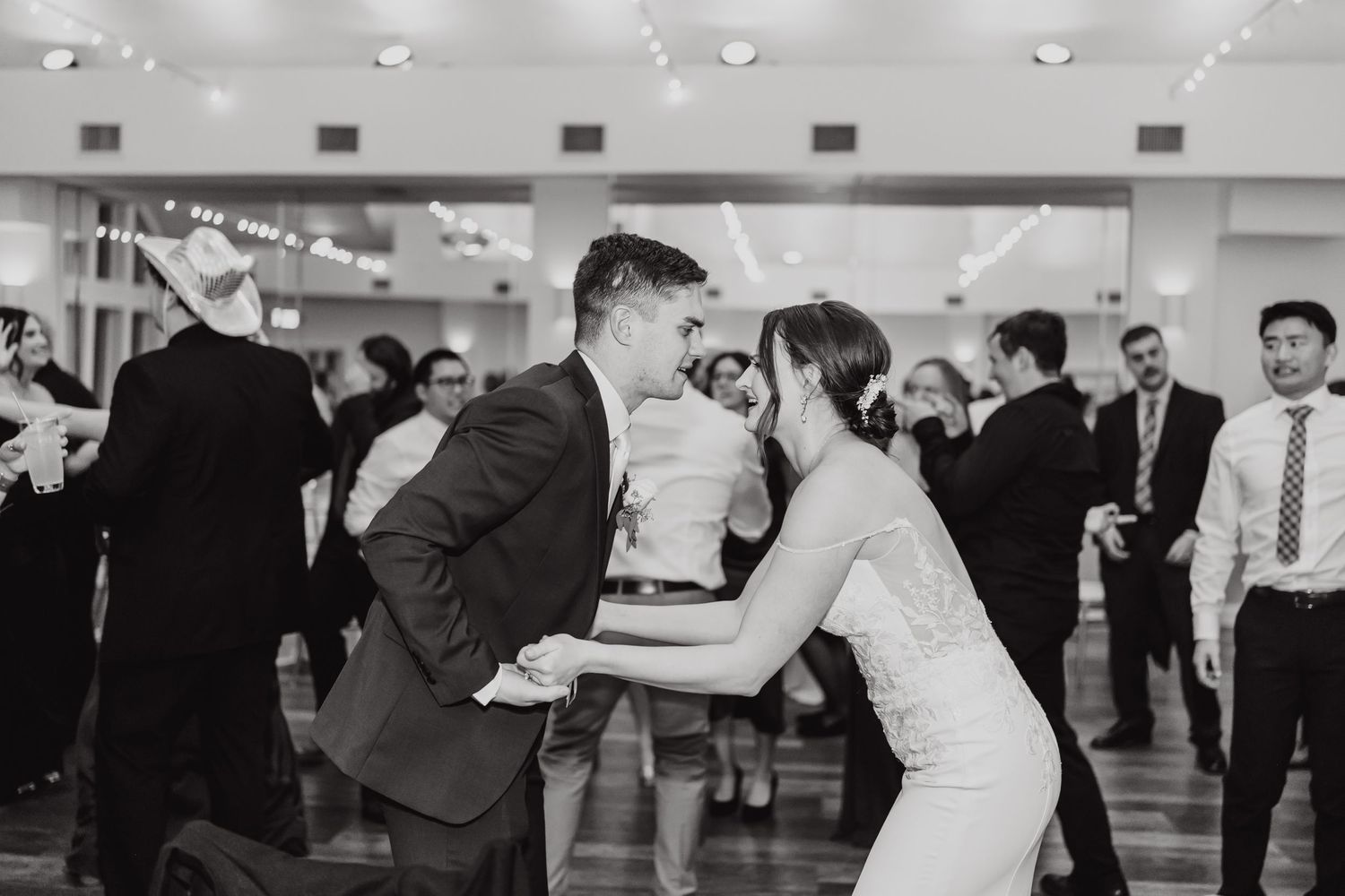 Black and white photos of wedding guests dancing at a lively reception.