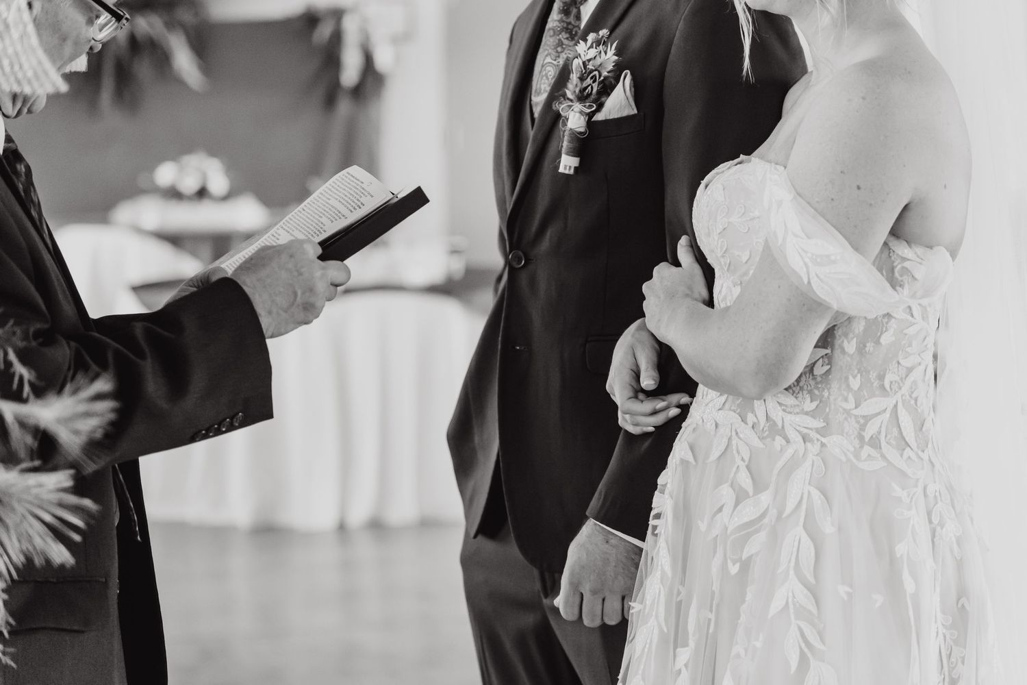 Close-up of a wedding ceremony with focus on hands and formal attire.