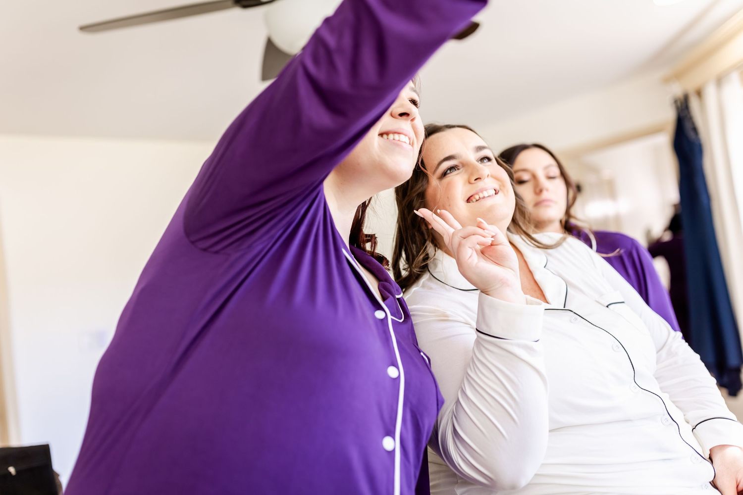 Wedding party members dance and celebrate with joyful expressions during preparations.