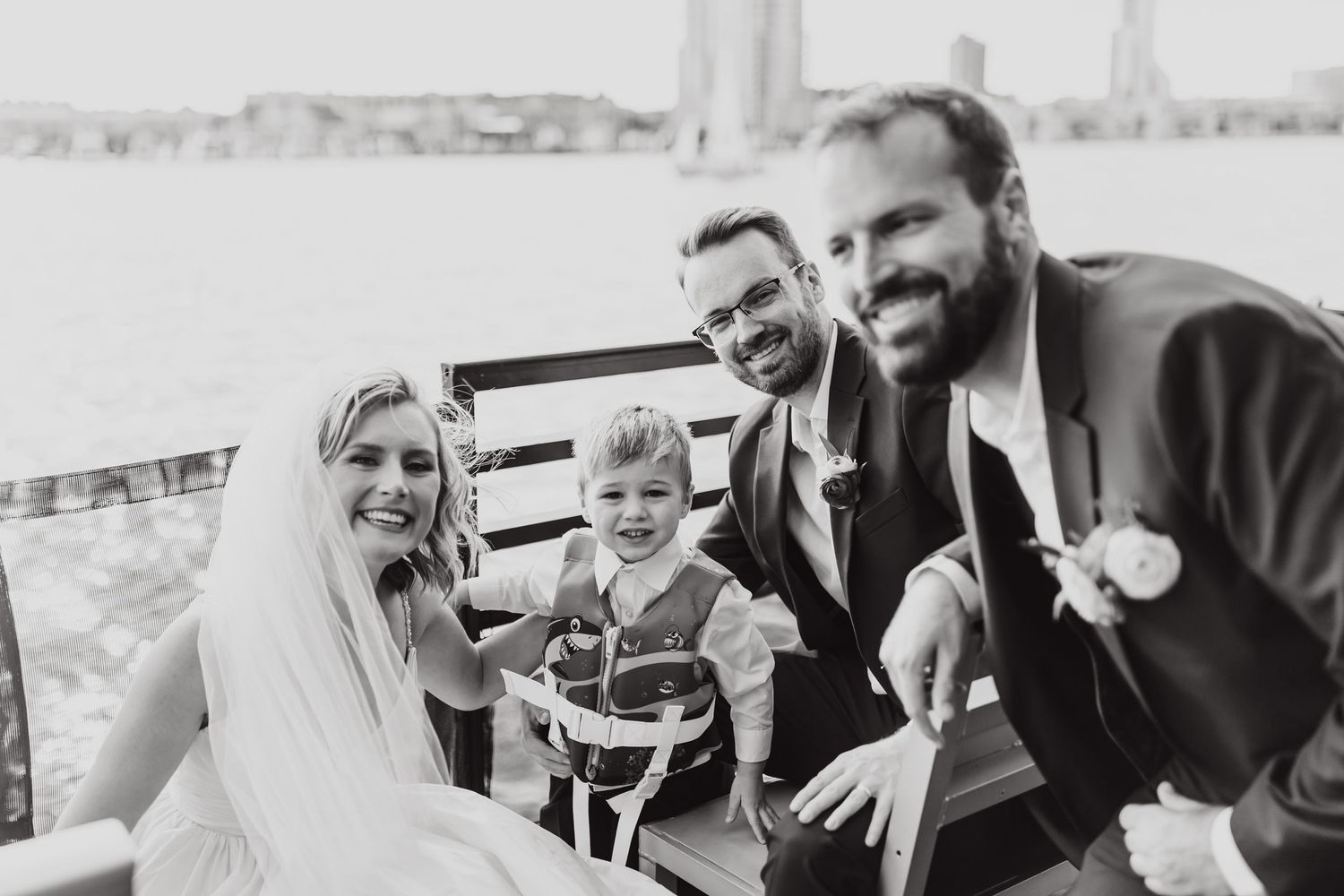 Wedding party enjoying a joyful moment together on boat deck.