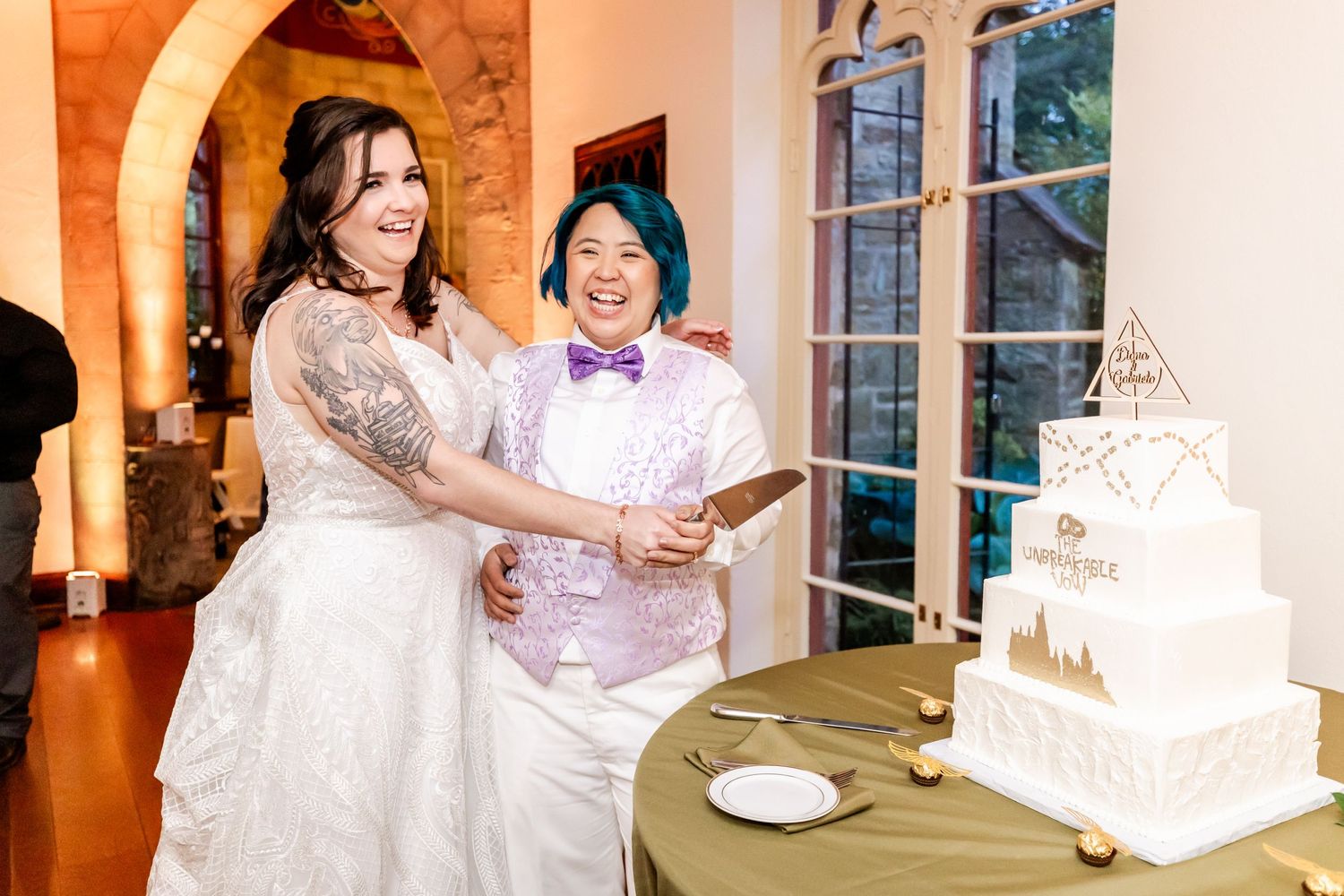 A joyful first dance in an elegant wood-paneled reception hall with guests watching.