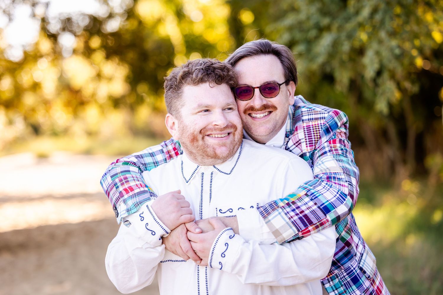 Family members share warm embraces during an outdoor photo session at sunset.