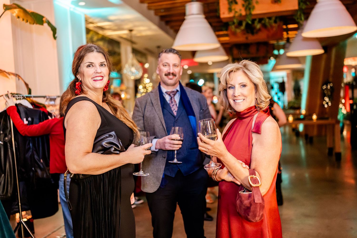 Group of people mingling and socializing at an elegant evening event with ambient lighting.