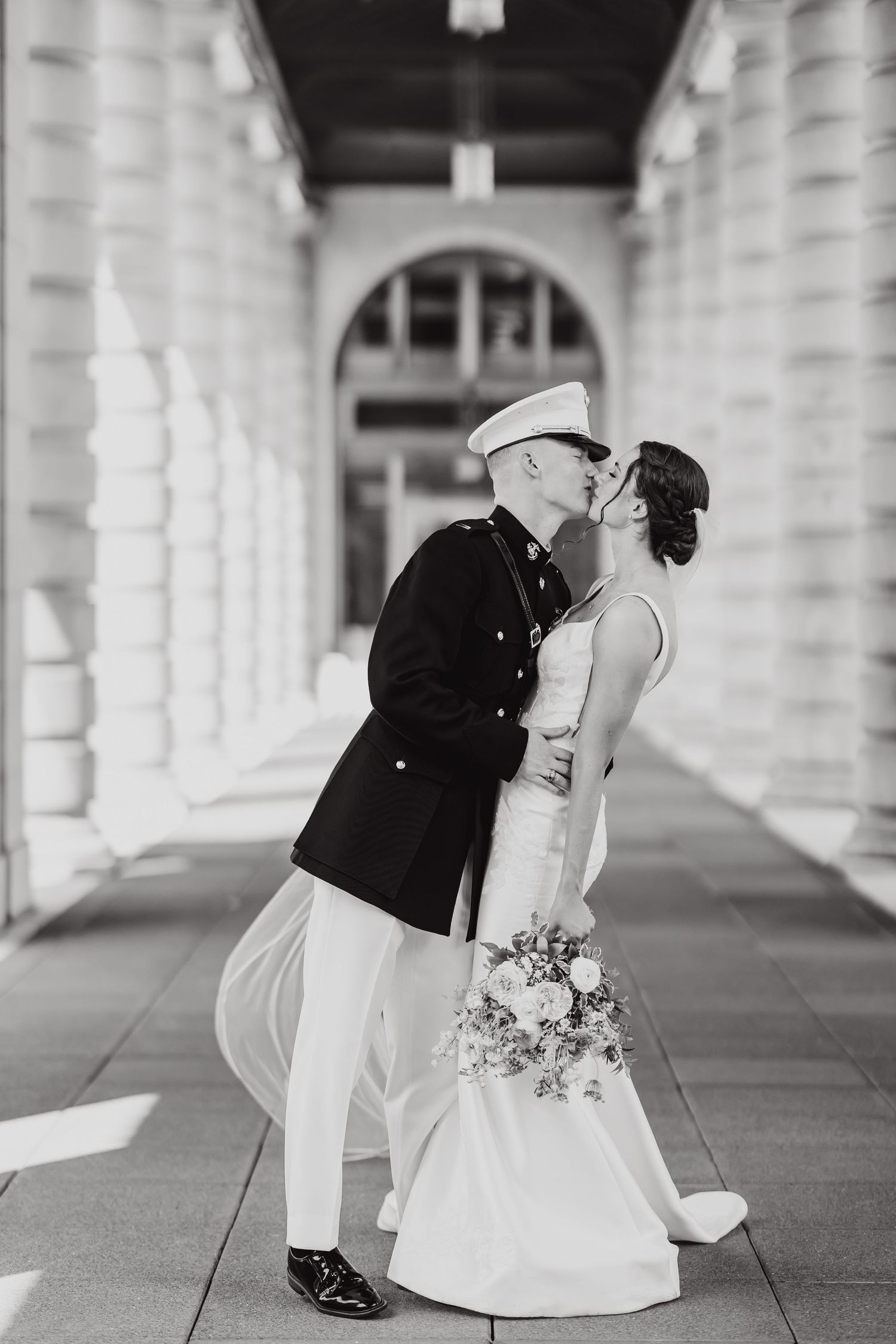 Black and white photos of a wedding couple posing romantically under an elegant columned walkway.
