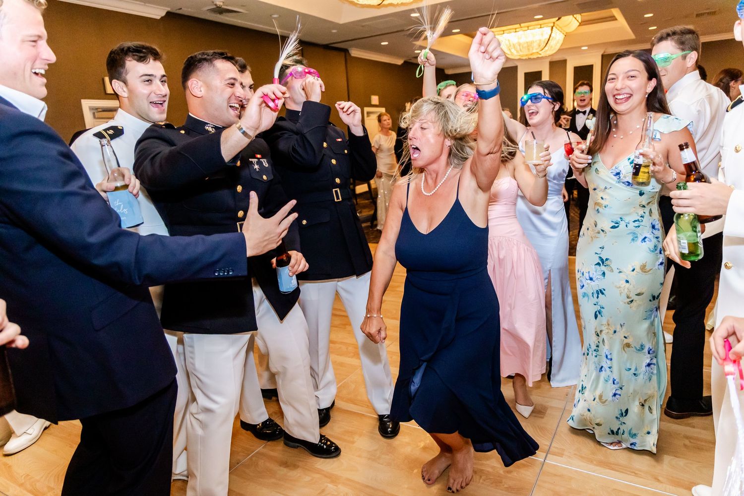 Energetic dance floor moments captured during wedding reception festivities.