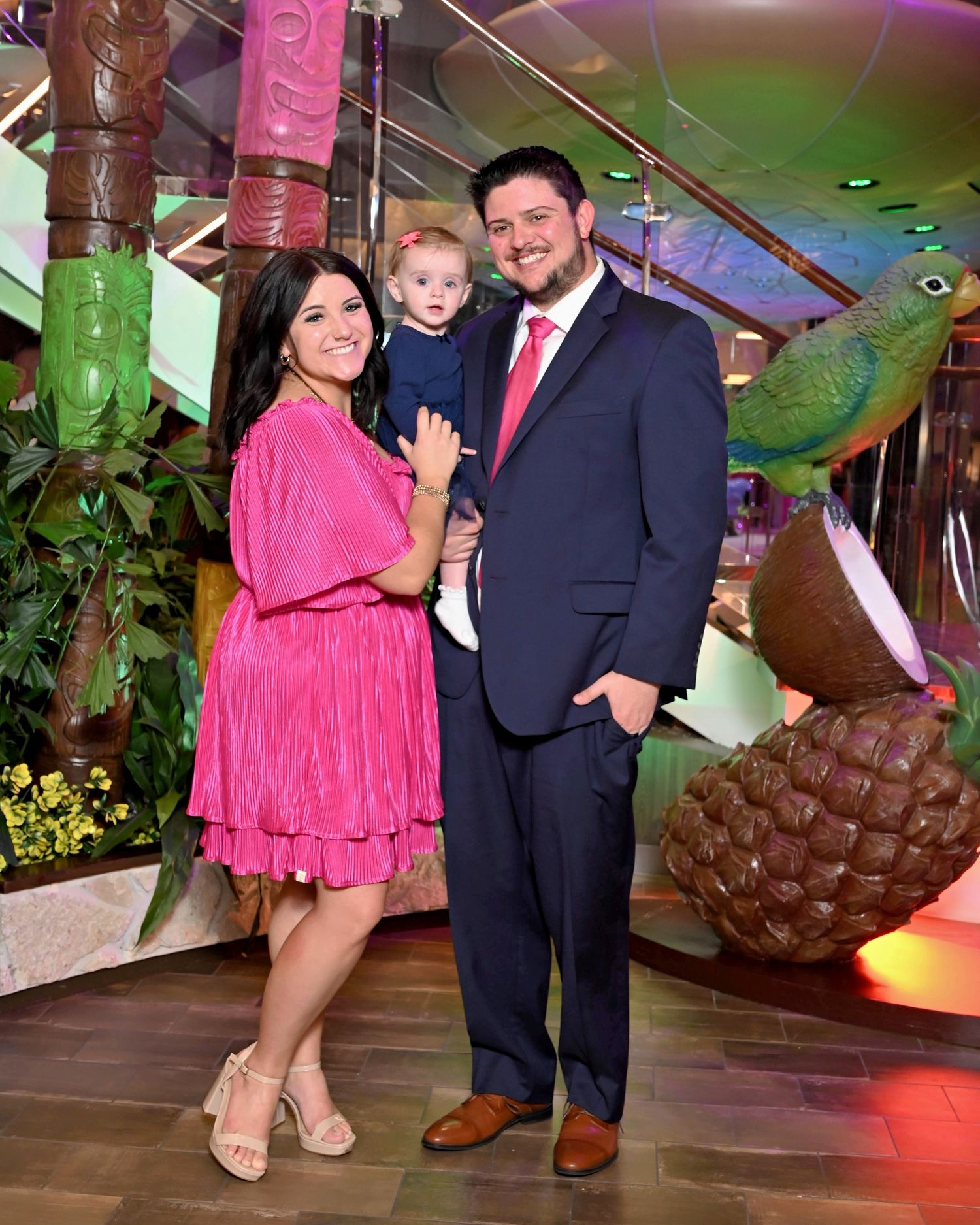 Celebration gathering with pink and navy outfits in tropical-themed party venue.