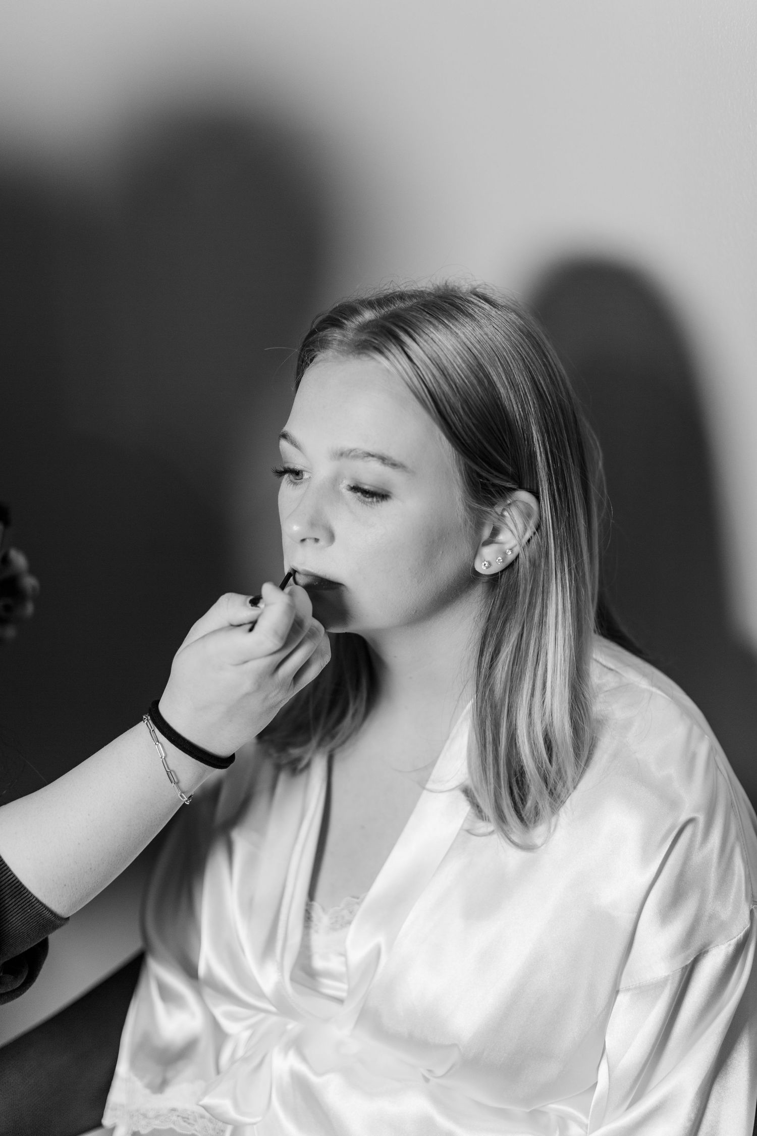 Getting ready scene with makeup application in black and white photography.