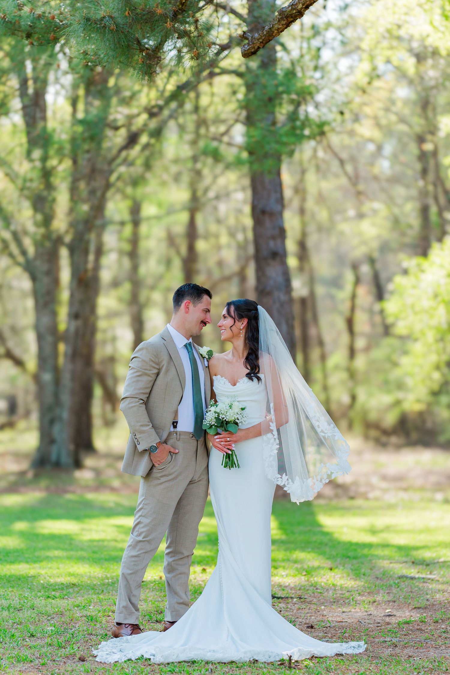 A romantic wedding photoshoot sequence showing a couple in formal attire posing together in a sunlit wooded area.