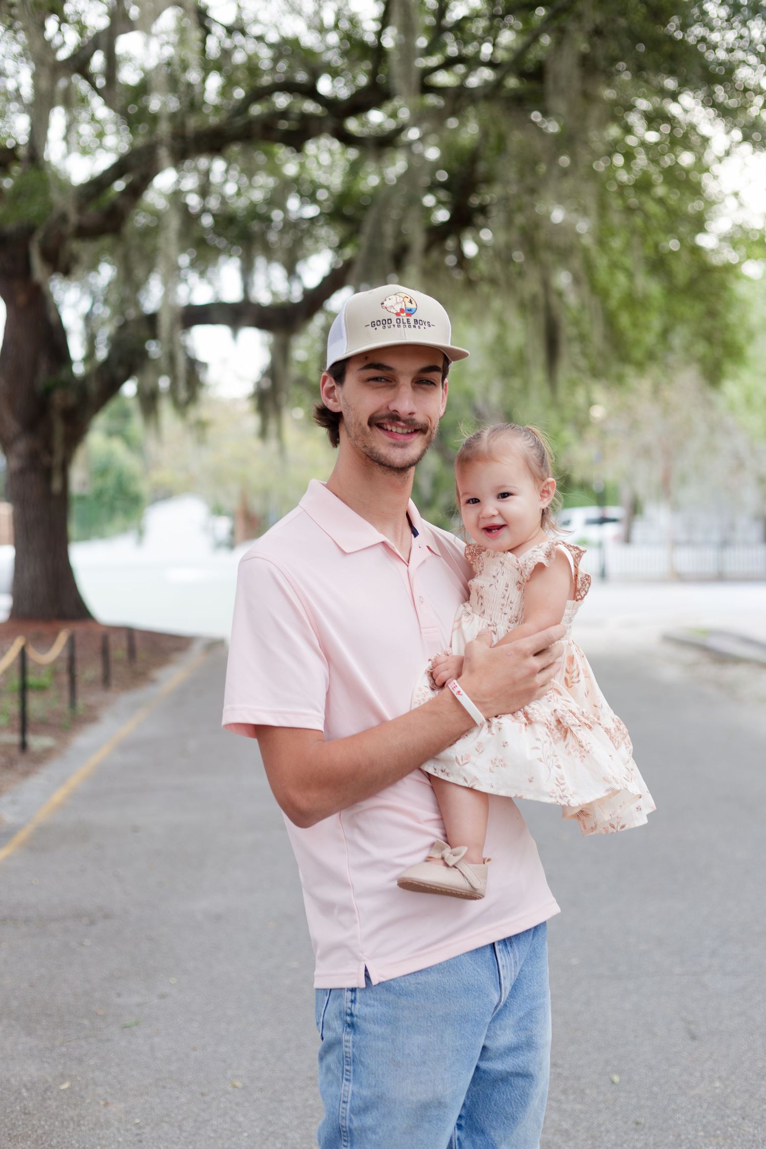 A casual outdoor portrait under Spanish moss trees.