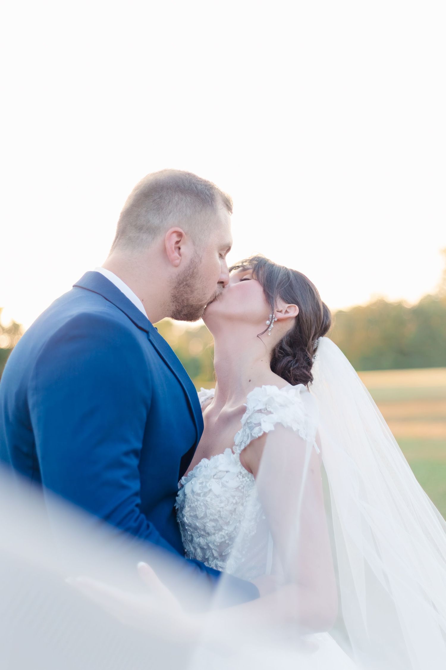 Dreamy sunset wedding portraits show tender moments between newlyweds.