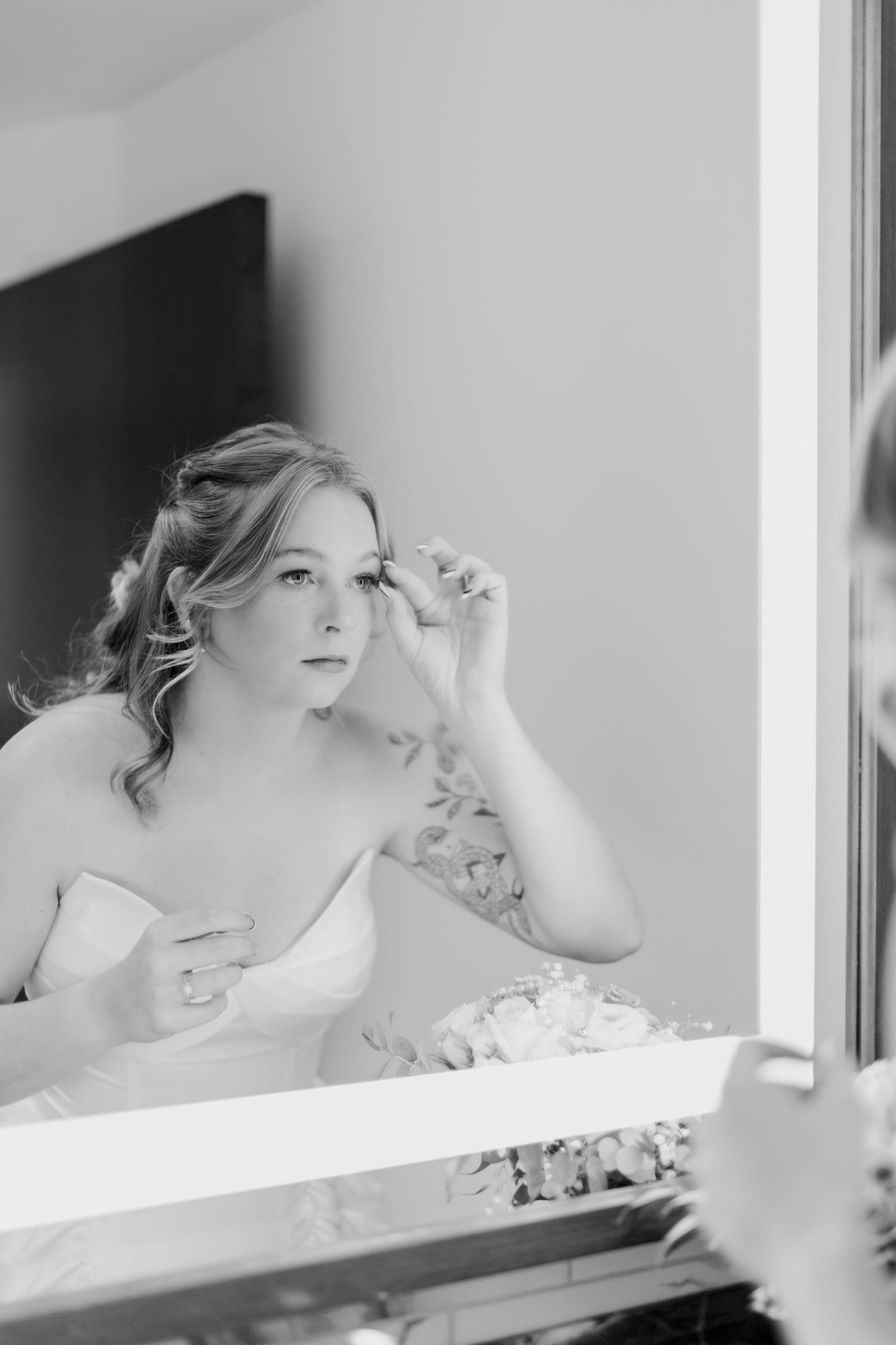 Artistic black and white portrait through window panes showing soft romantic mood.