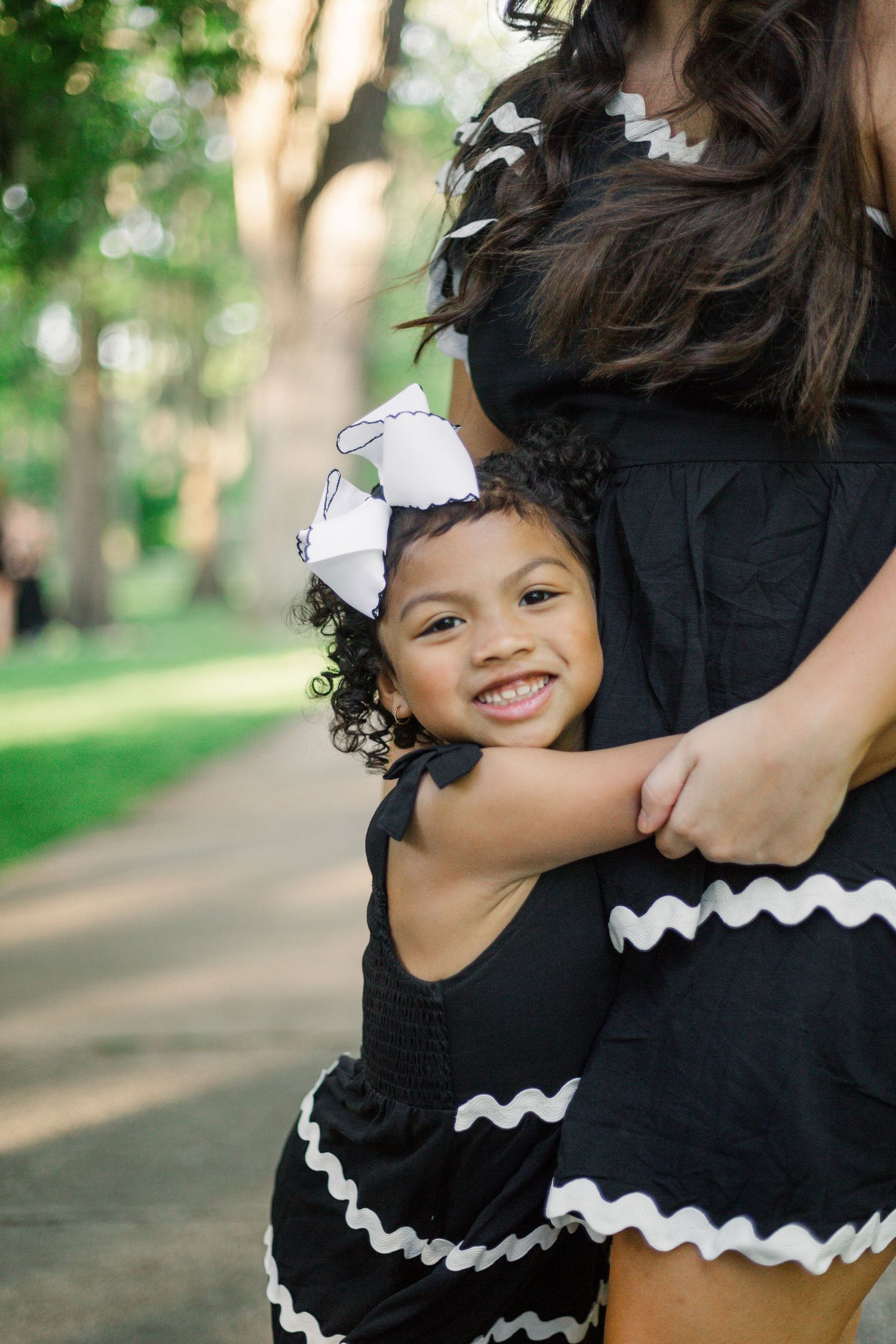 A joyful embrace captured in matching black and white outfits with rick rack trim.