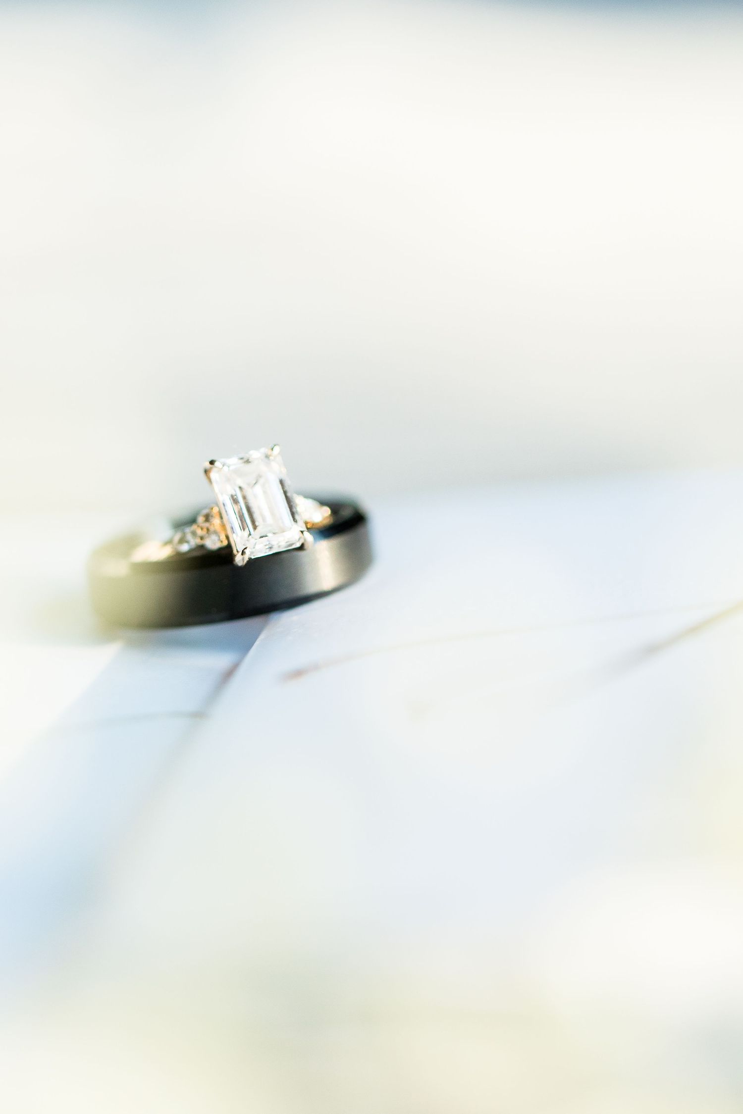 A close-up macro shot of a diamond engagement ring with blurred background.