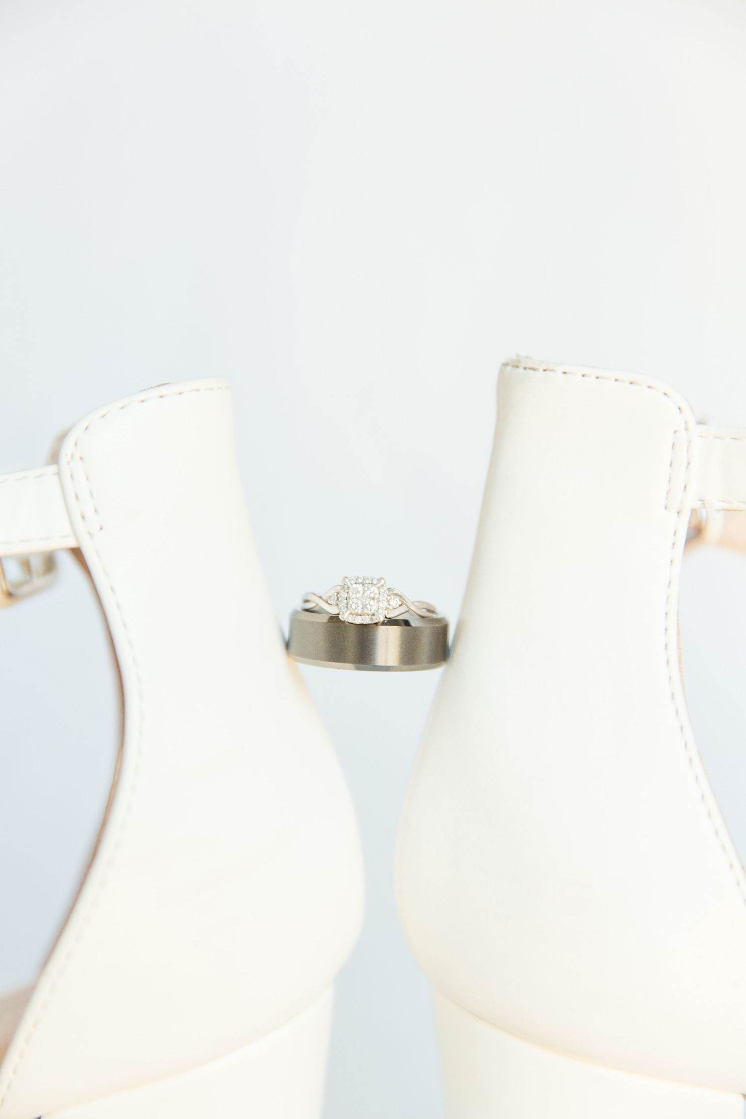 Wedding jewelry displayed on white surface in natural light.