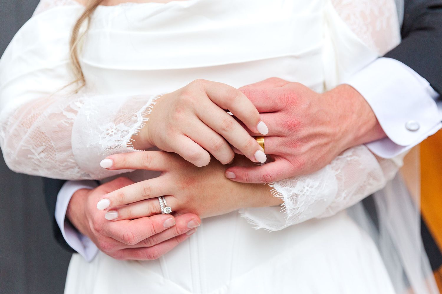 Close up of hands exchanging wedding rings during ceremony.