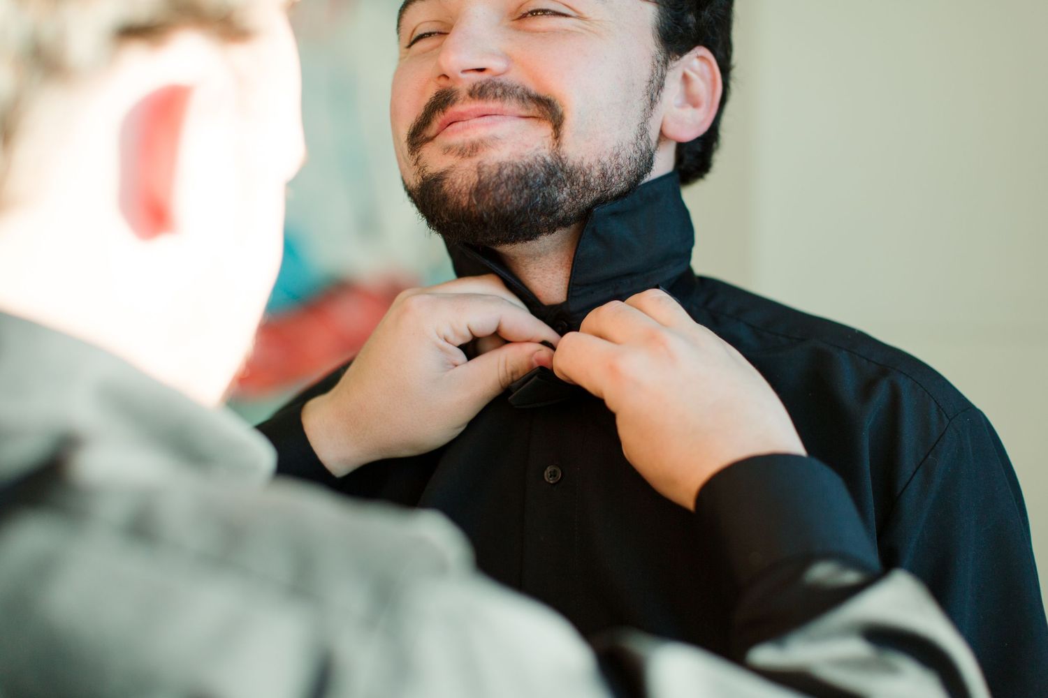 Groom preparation photos in natural light setting.