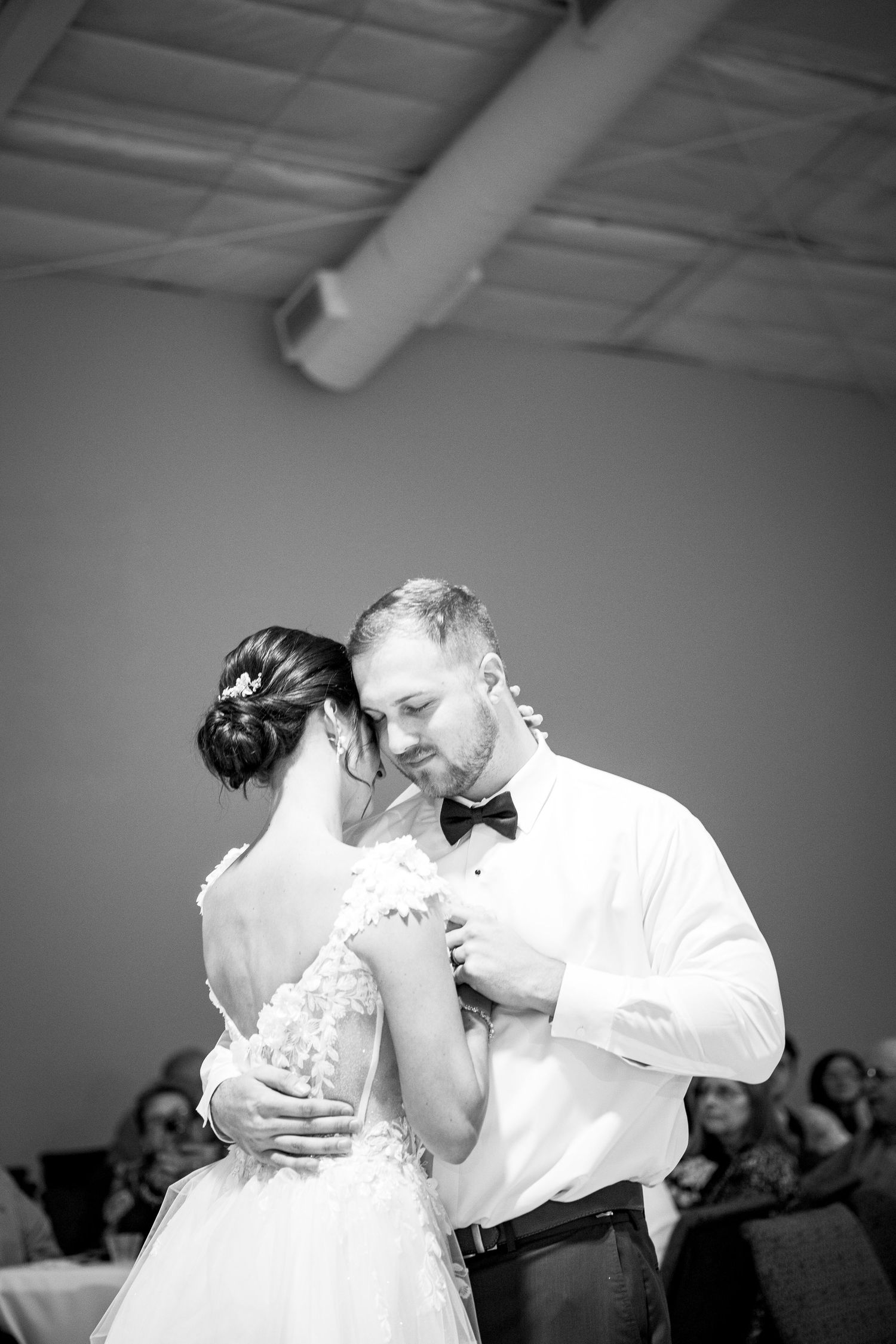 Black and white photo of a couple's first dance at their wedding reception.