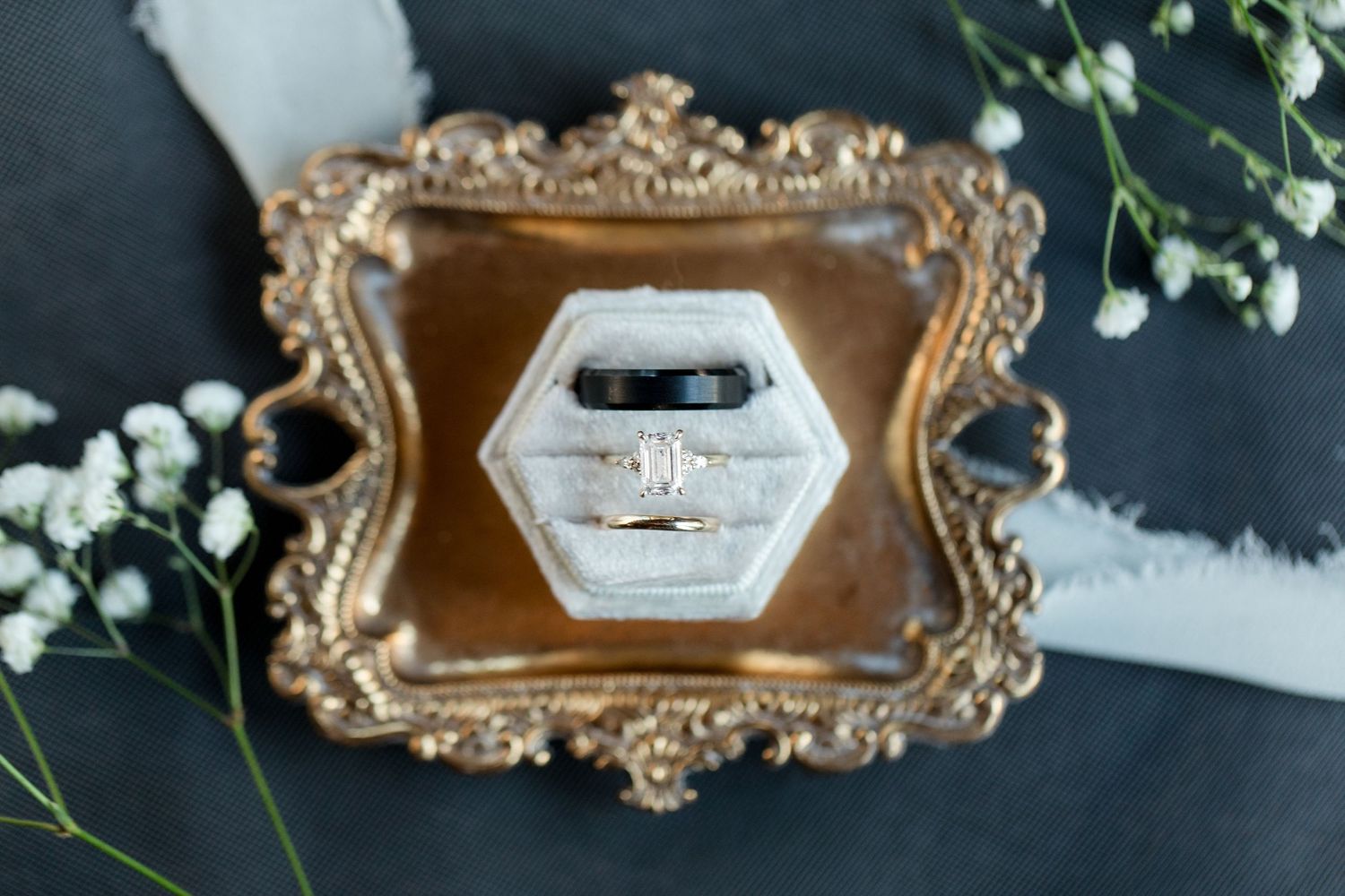 A vintage gold ornate frame displays a black and white hexagonal design on a dark background with greenery accents.
