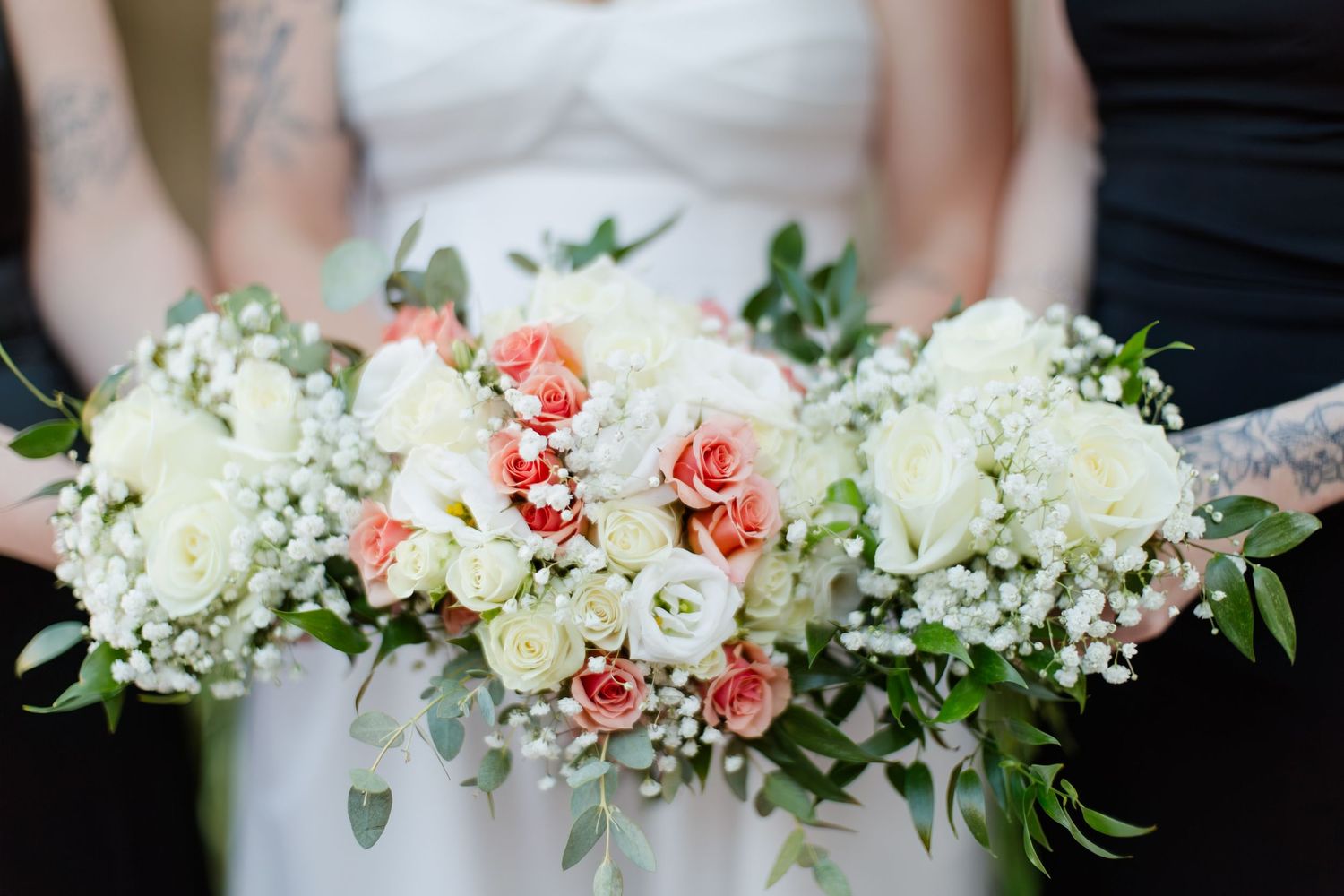Elegant wedding bouquets featuring coral and white flowers with greenery.