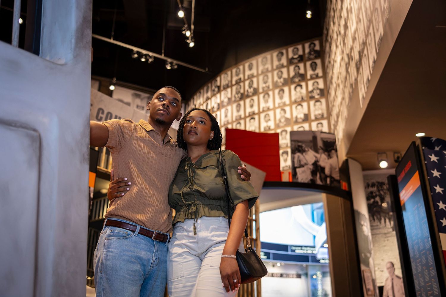 A couple explores an indoor museum exhibit, looking up at displays in a cultural history gallery.
