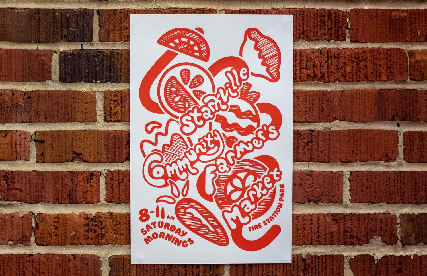 Red and white risograph printed poster for Seattle Community Farmers Market on brick wall background.