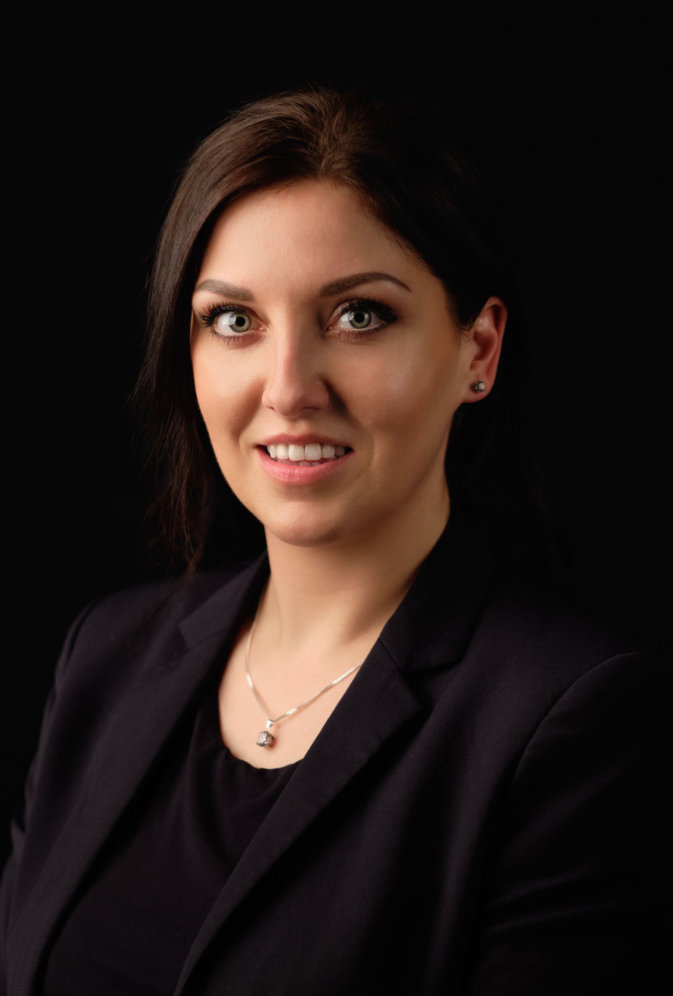 London studio portrait photography – confident female professional against black backdrop