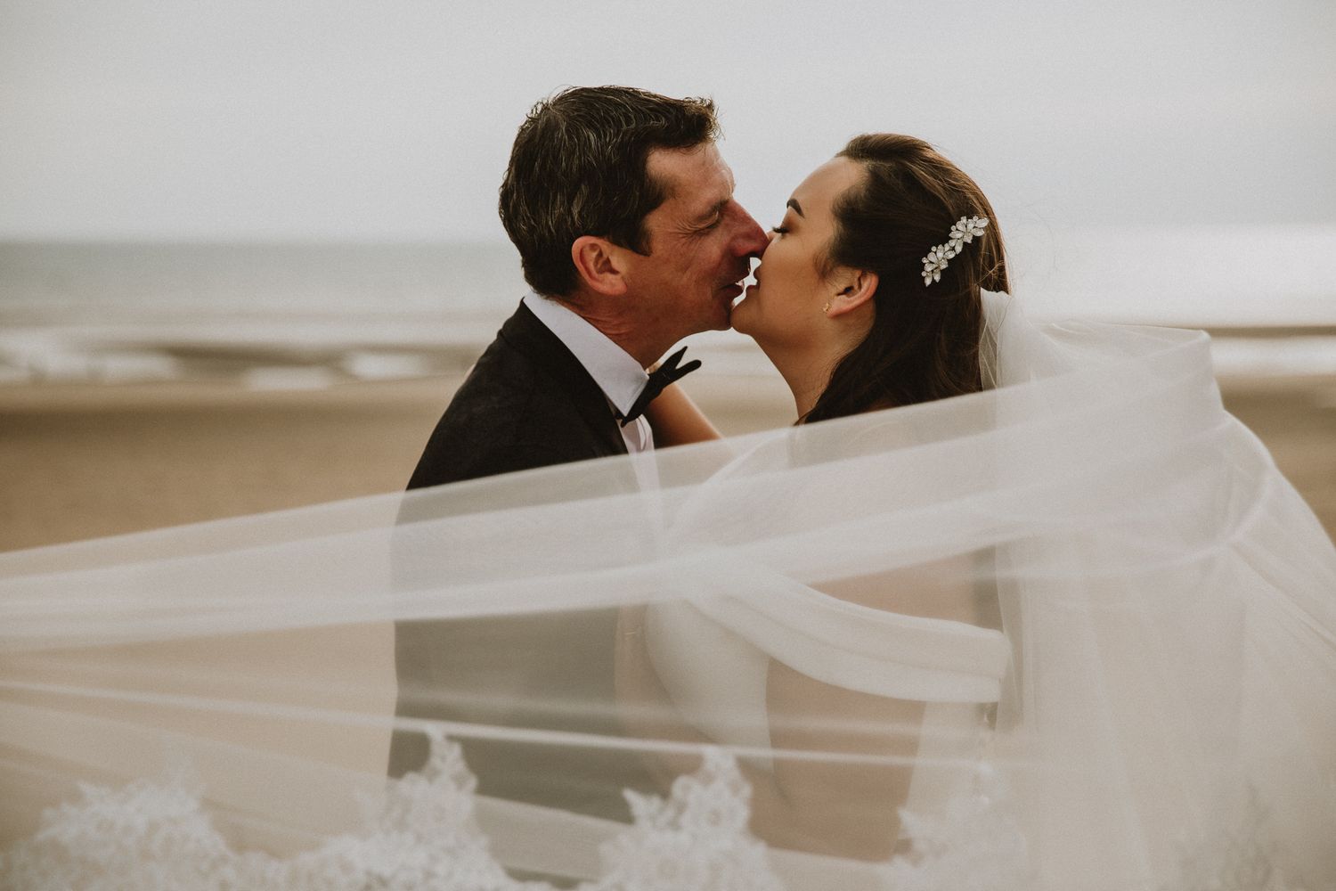 documentary wedding photography in Kent – candid kiss on sand dunes