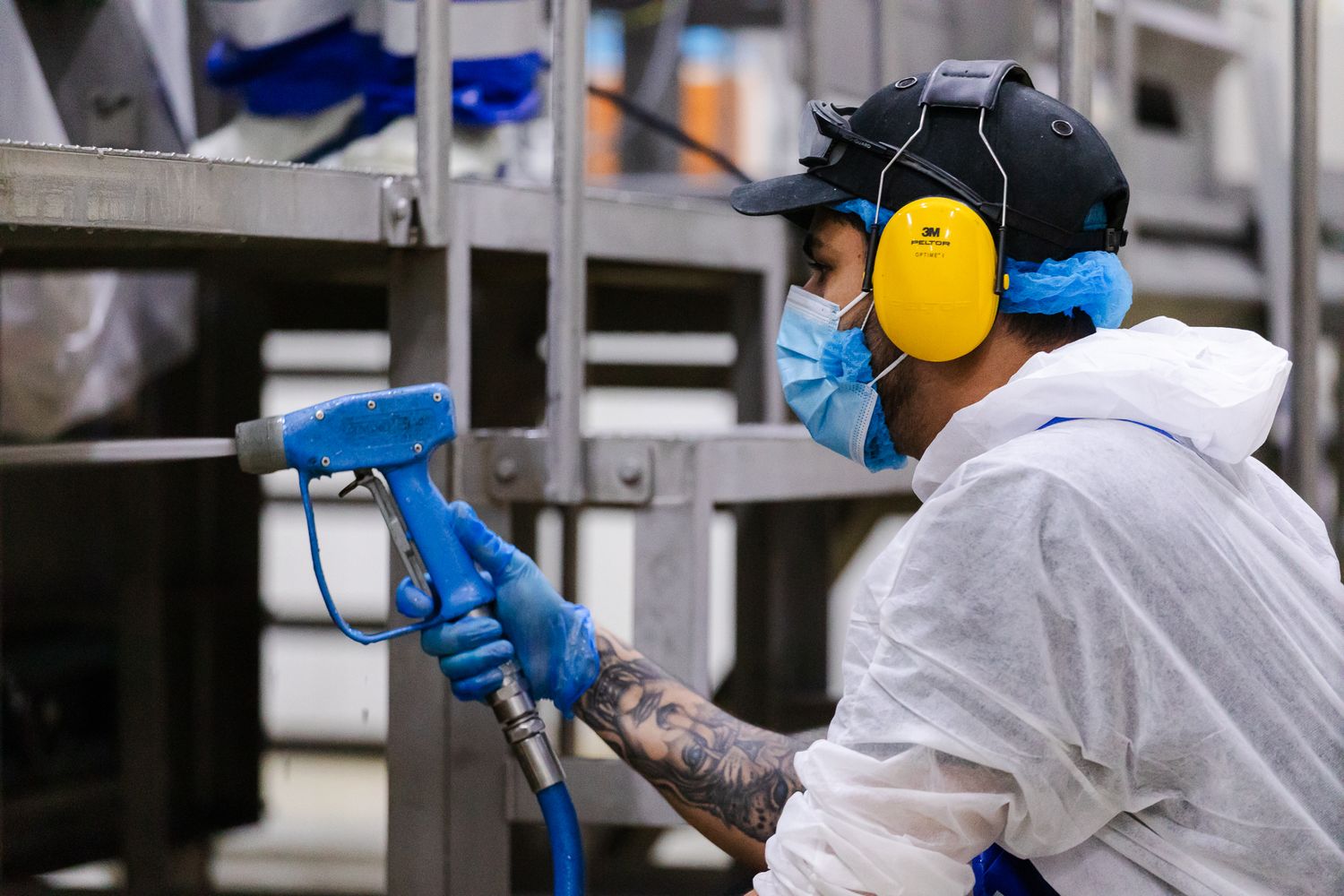ndustrial photography in Kent – worker cleaning machinery in rice production facility